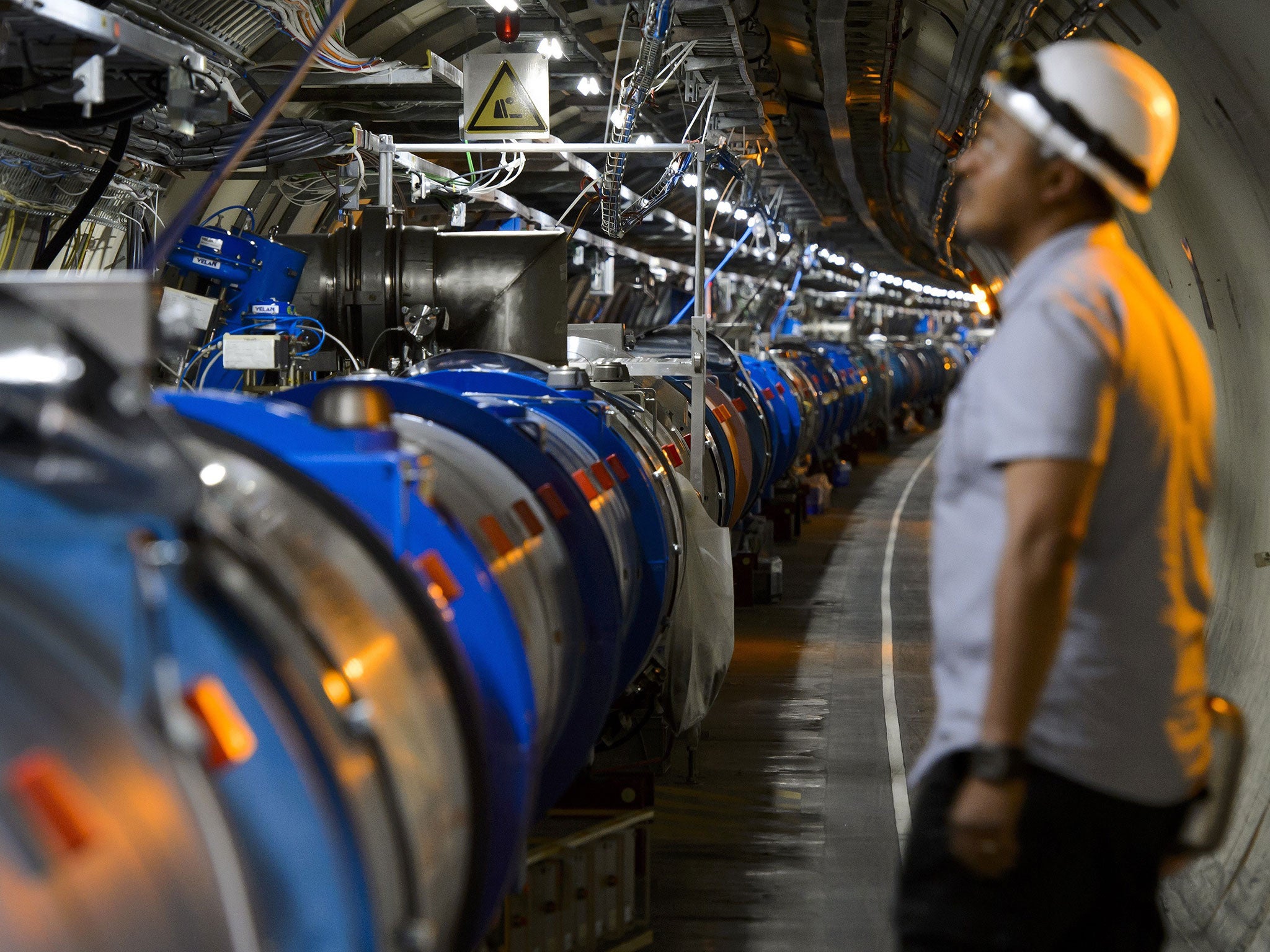 A scientist looks at a section of the Cern Large Hadron Collider during maintenance works in 2013 in Meyrin