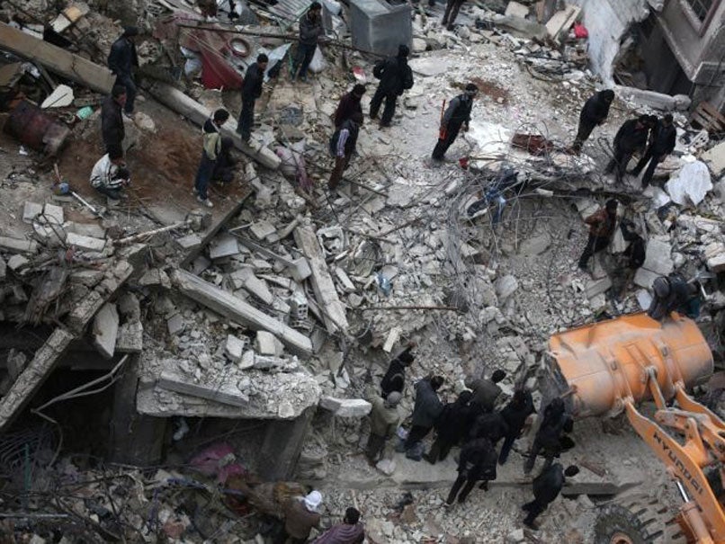 Syrian civilians search for survivors at the site of reported air strikes by regime forces in the rebel-held area of Douma on 9 February