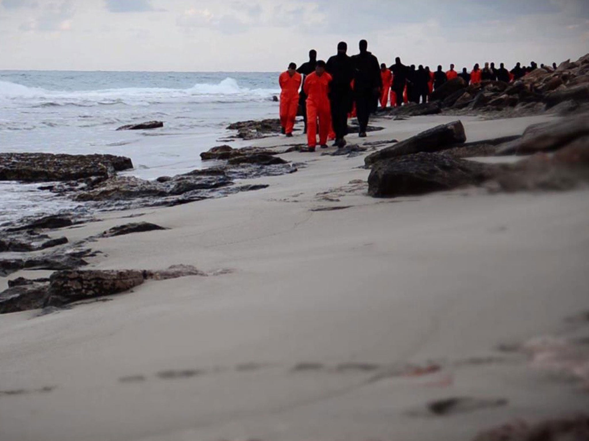 Isis fighters leading handcuffed hostages, said to be Egyptian Coptic Christians, before their alleged decapitation on a seashore in Tripoli