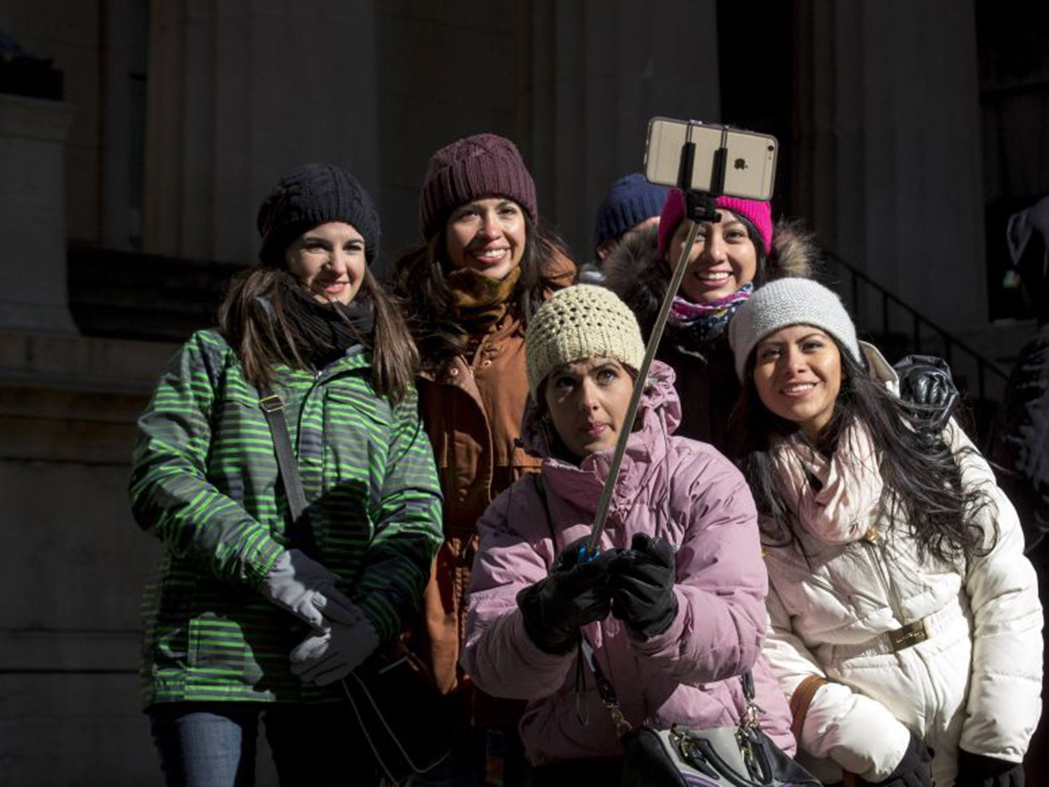 Tourists use a selfie stick outside a New York landmark