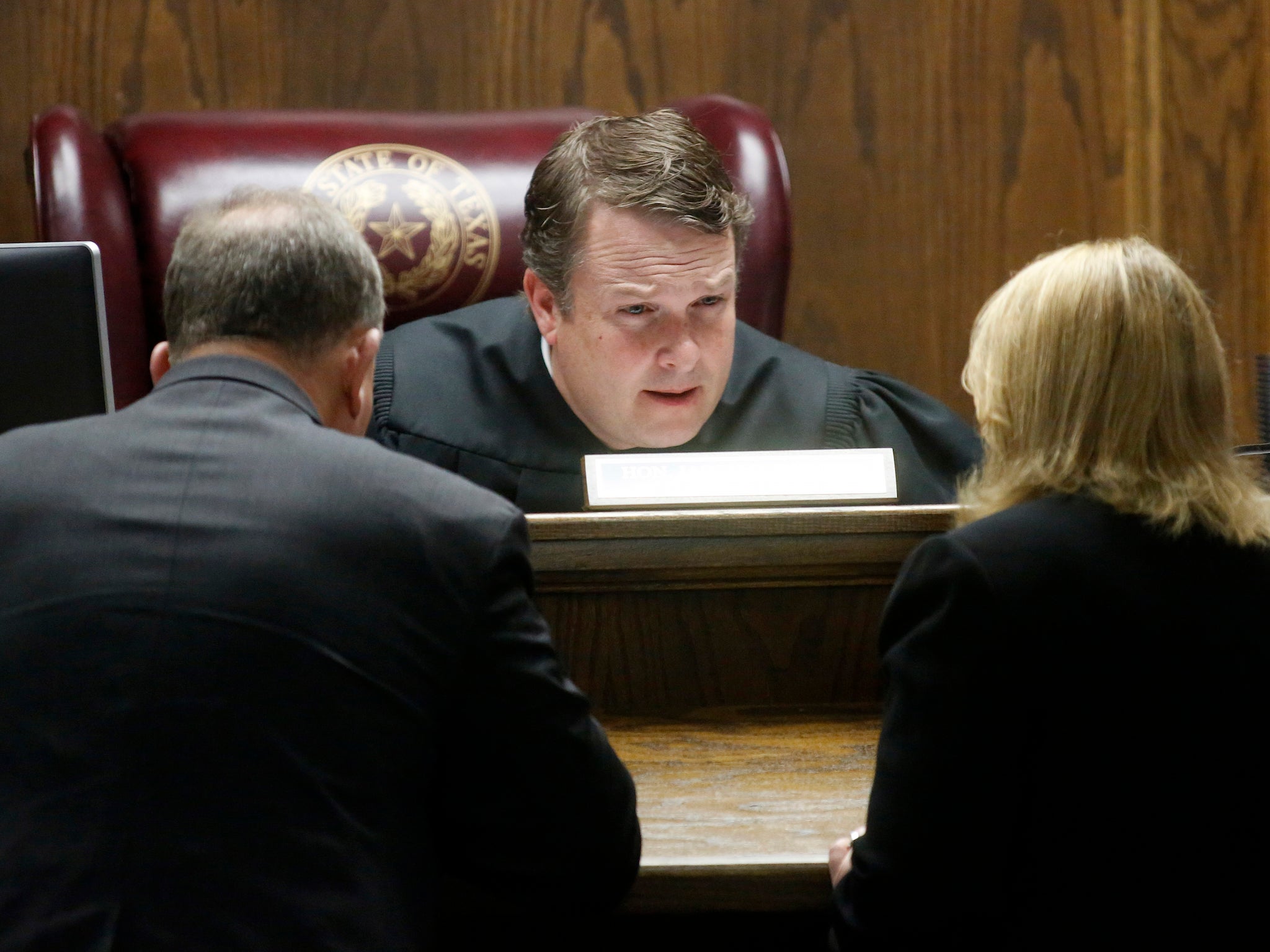 State District Judge Jason Cashon confers with court appointed defence lawyer Warren St John (L) and Erath Assistant District Attorney Jane Starnes