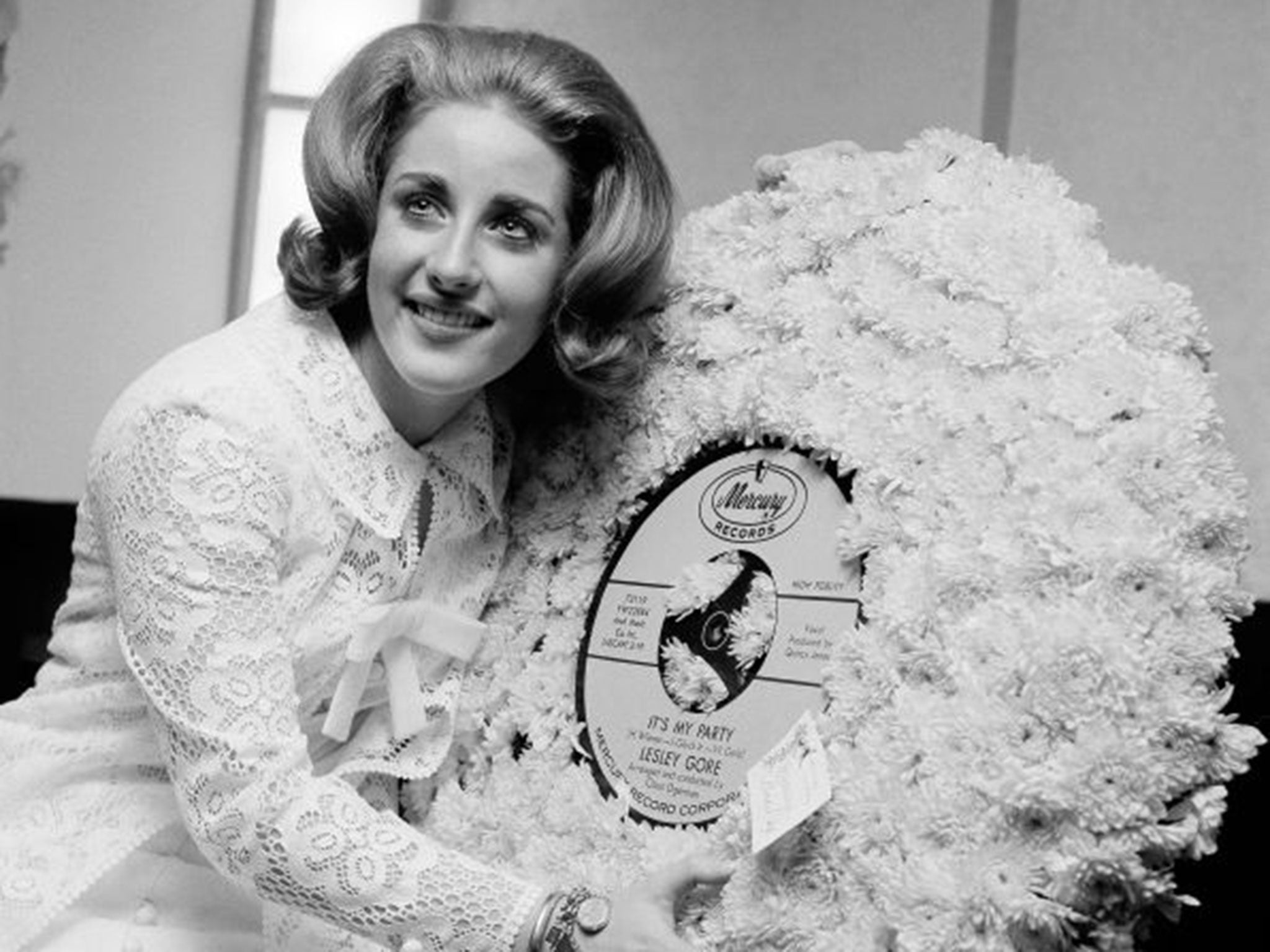 Gore hugs a flowered record at her 18th birthday party celebrated at the Delmonico Hotel in New York in 1964 (Getty Images)