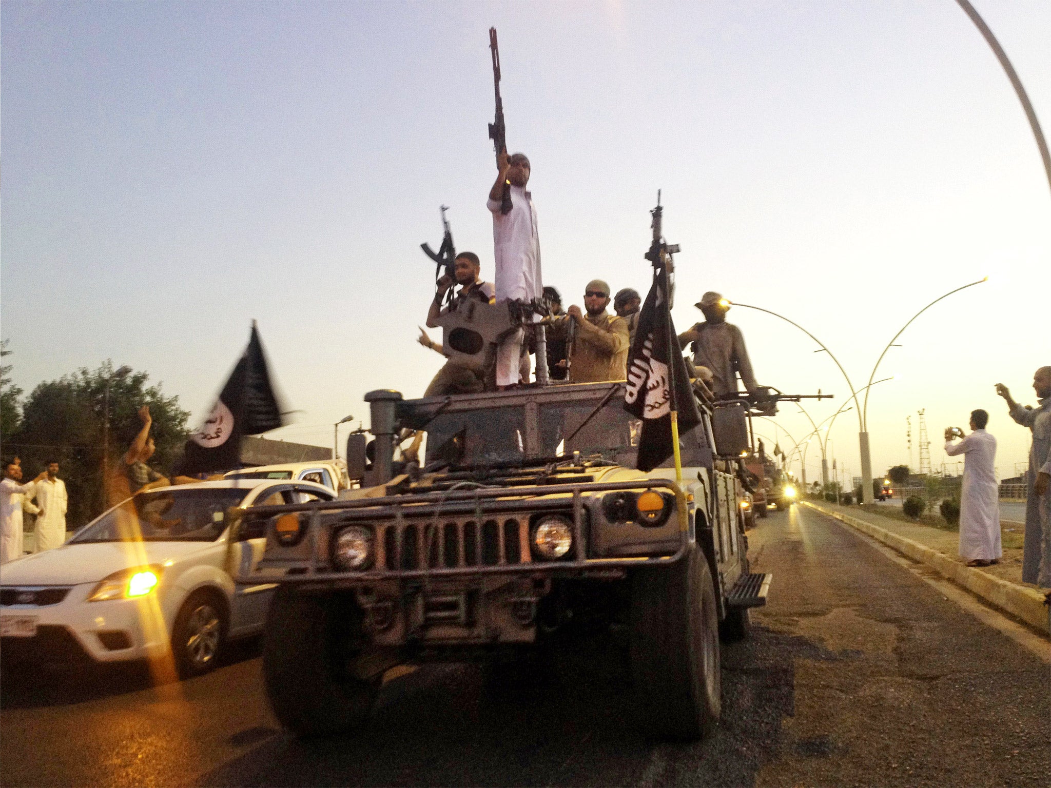 Isis fighters parading in a captured Iraqi army vehicle in Mosul, which the group took in June last year