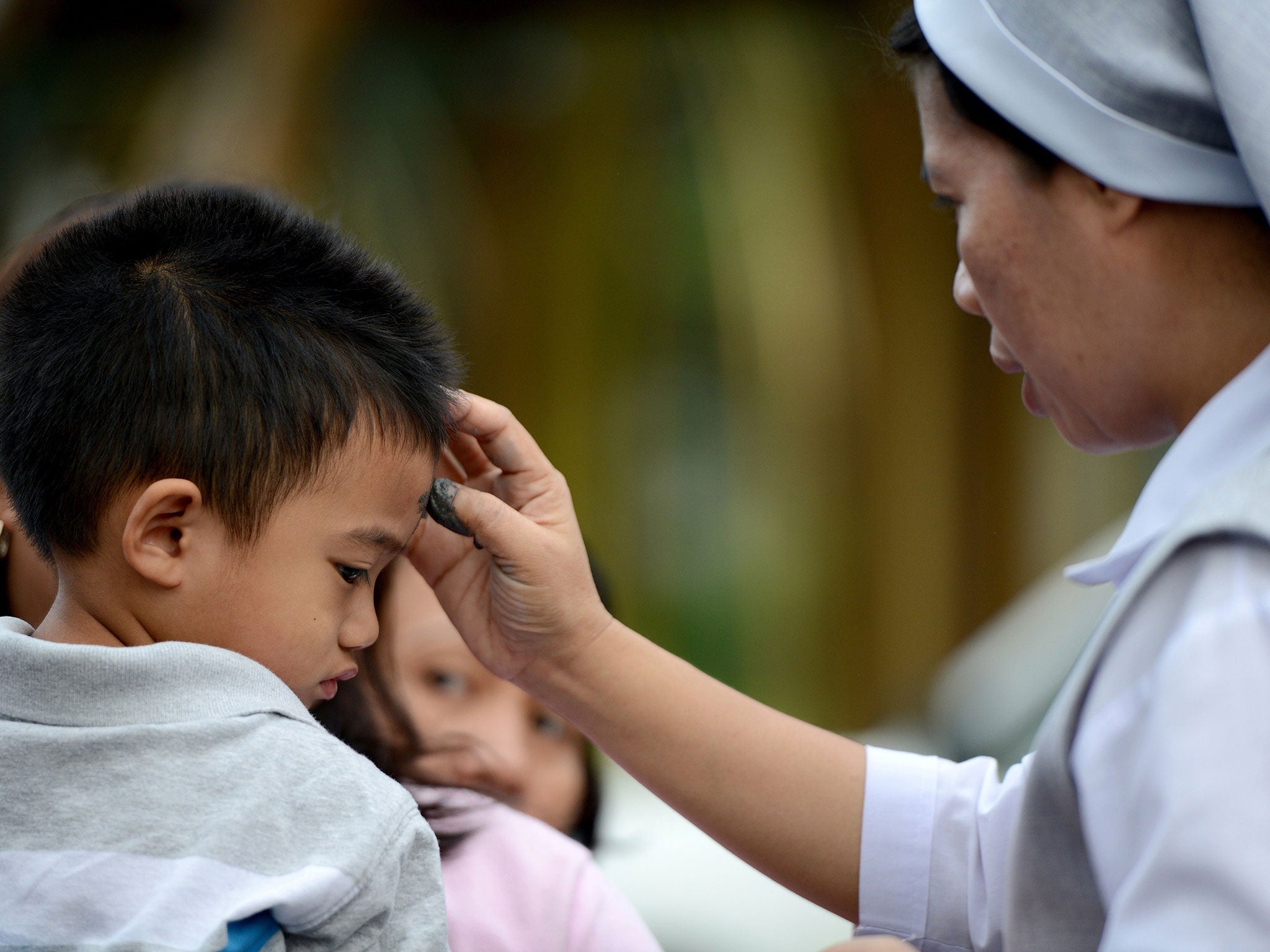 Roman Catholics queue up to have crosses etched to their foreheads with ash by nuns and laymen as the country marks Ash Wednesday, the official beginning of the Christian Lenten season in Manila, Philippines