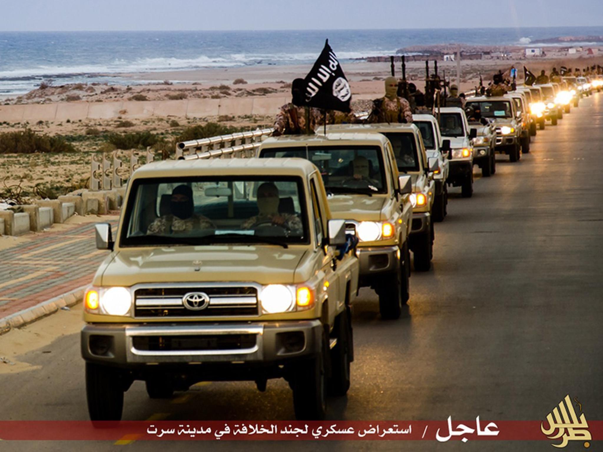 Isis militants process down a street in the coastal city of Sirte in Libya