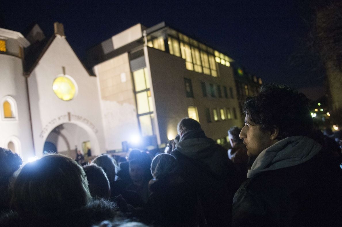 People gather as Norwegian Muslims create a human peace ring around the synagogue in Oslo