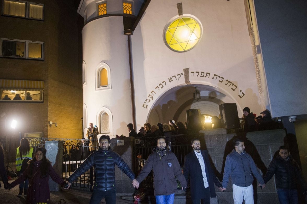 Norwegian Muslims create a human peace ring around the synagogue in Oslo