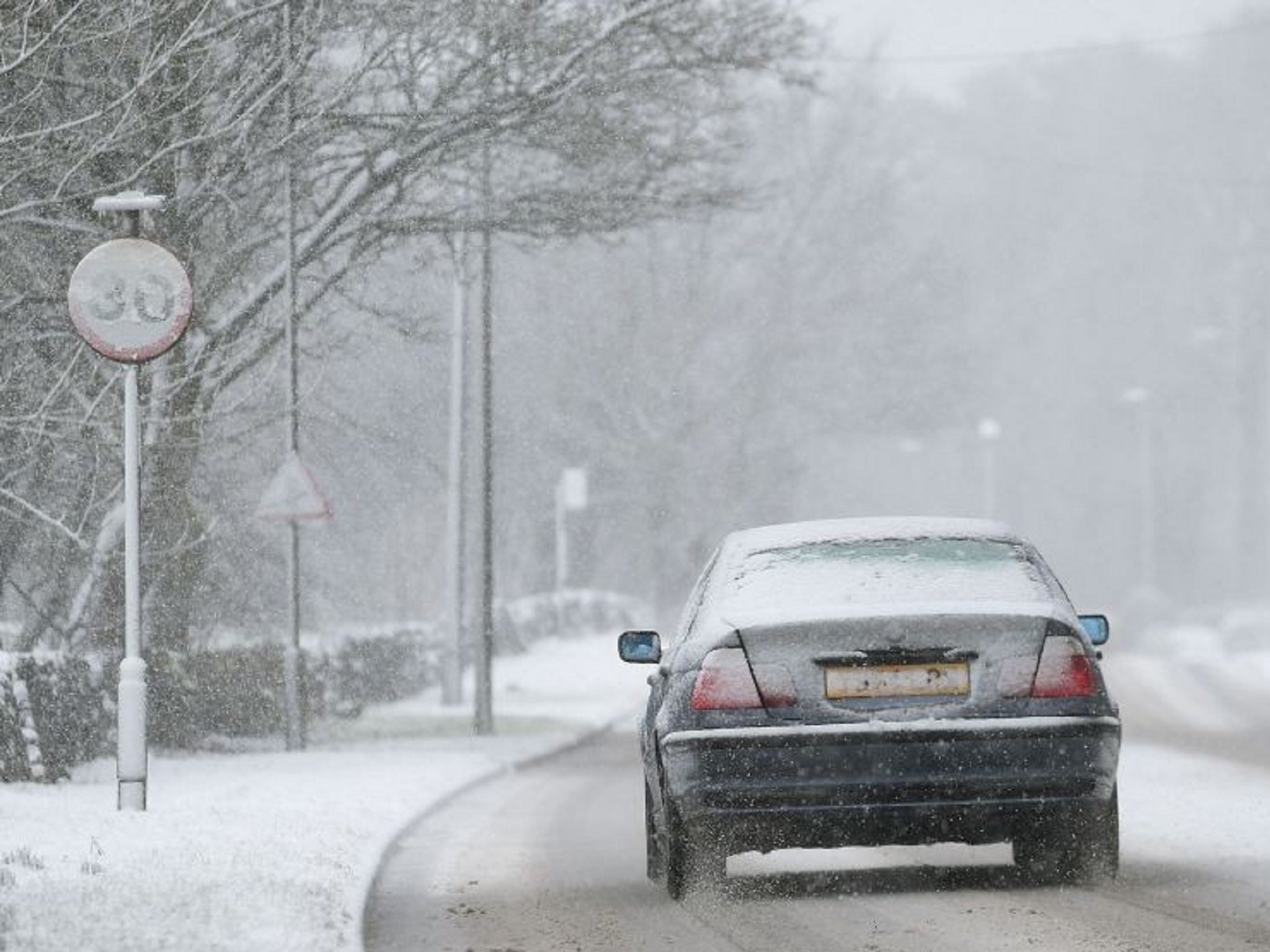 A car makes its way through sleet and snow in Buxton, Derbyshire, on Sunday