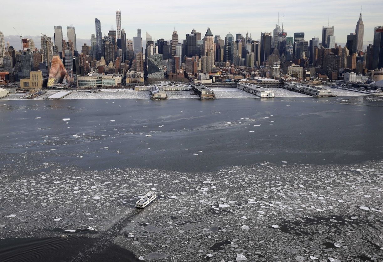 A boat travels across the Hudson River towards Manhattan island in New York City