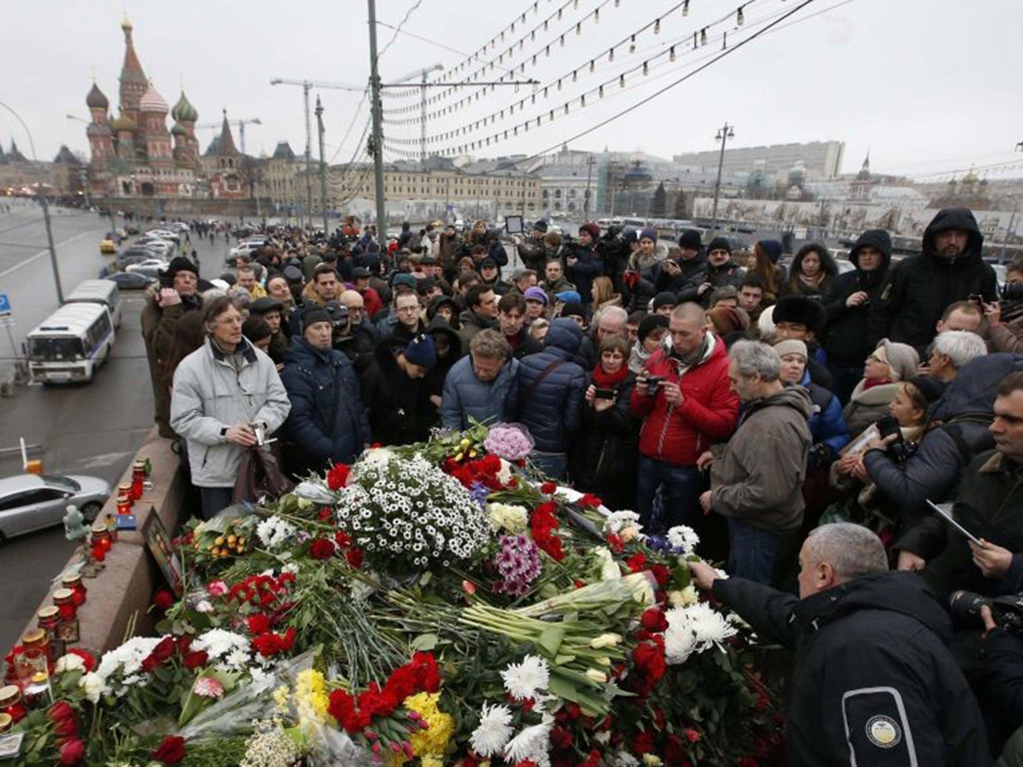 People gather at the site where Boris Nemtsov was murdered, with St. Basil's Cathedral seen in the background, in central Moscow, February 28, 2015.