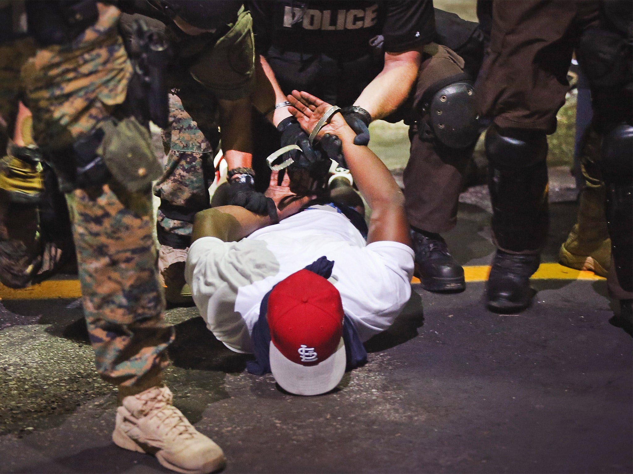 Missouri police arrest a demonstrator protesting the killing of teenager Michael Brown in Ferguson, last August