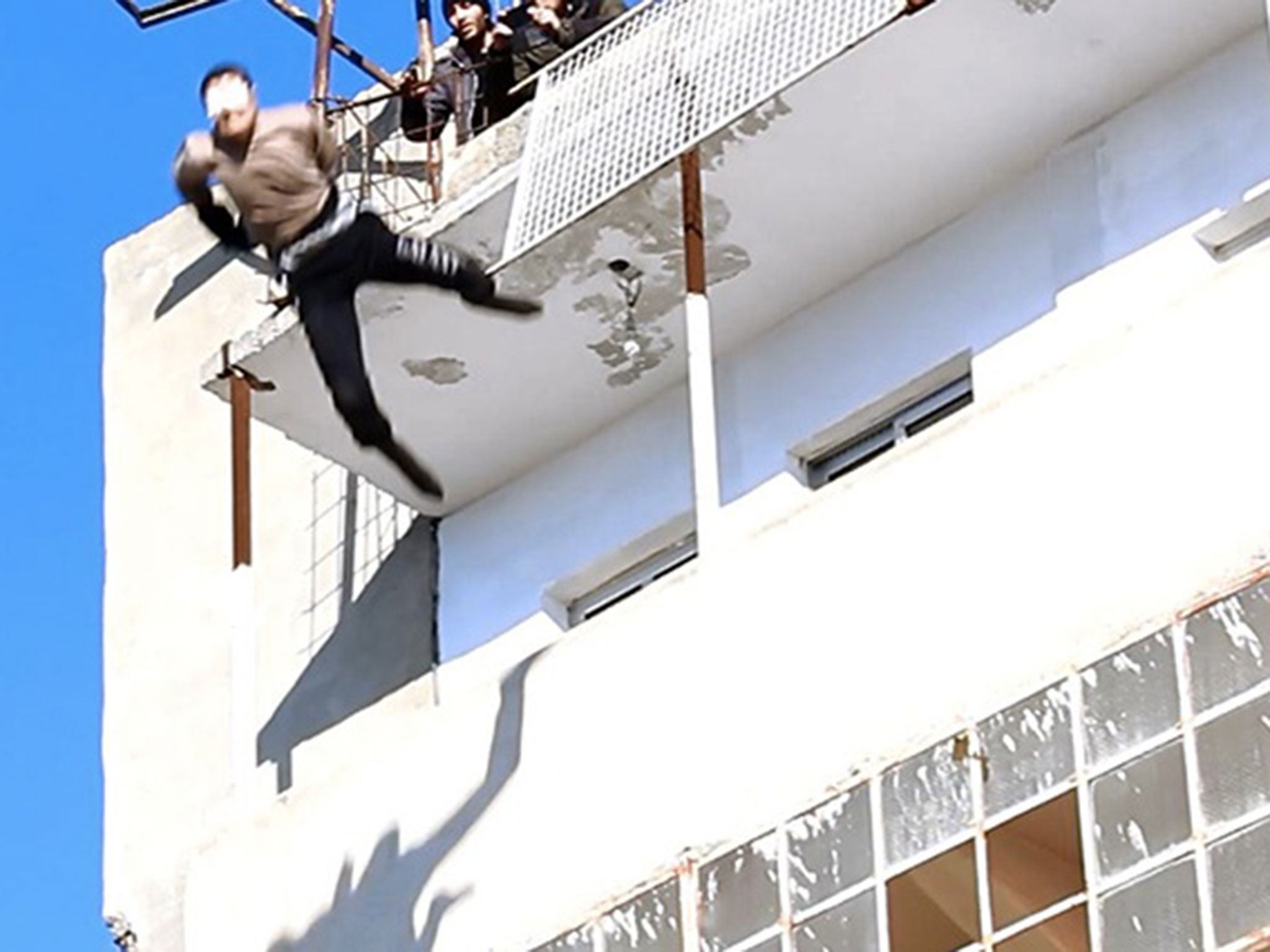 The man is thrown from the building by militants