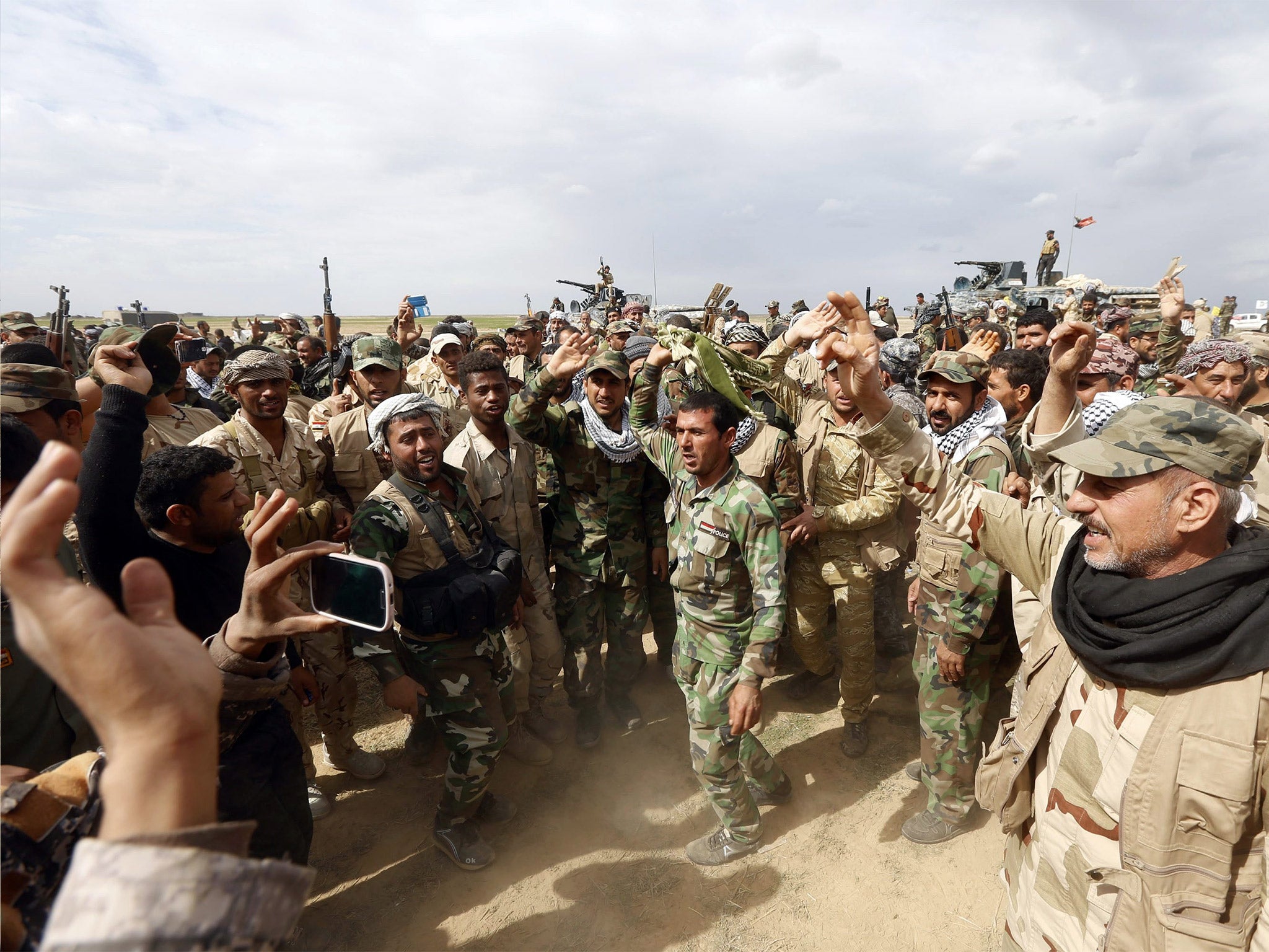 Iraqi troops and Shia Muslim fighters celebrate a successful action against Isis in Hamrin, Salahuddin province