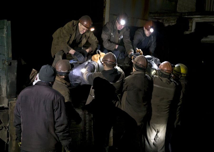 Ukrainian coal miners load the bodies of colleagues killed in this morning's explosion the Zasyadko mine in Donetsk, Ukraine