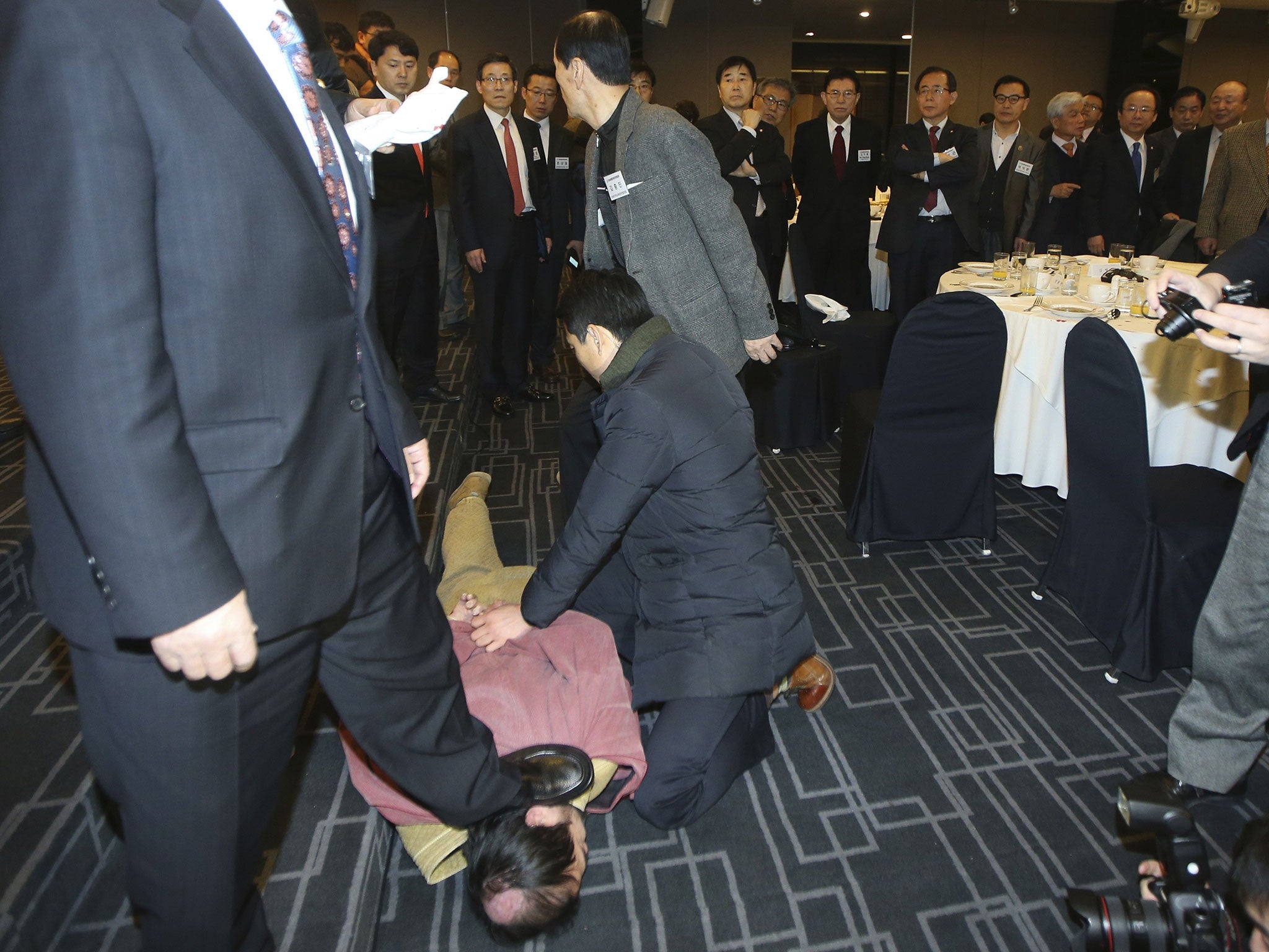 Security personnel detain an assailant who attacked the US ambassador