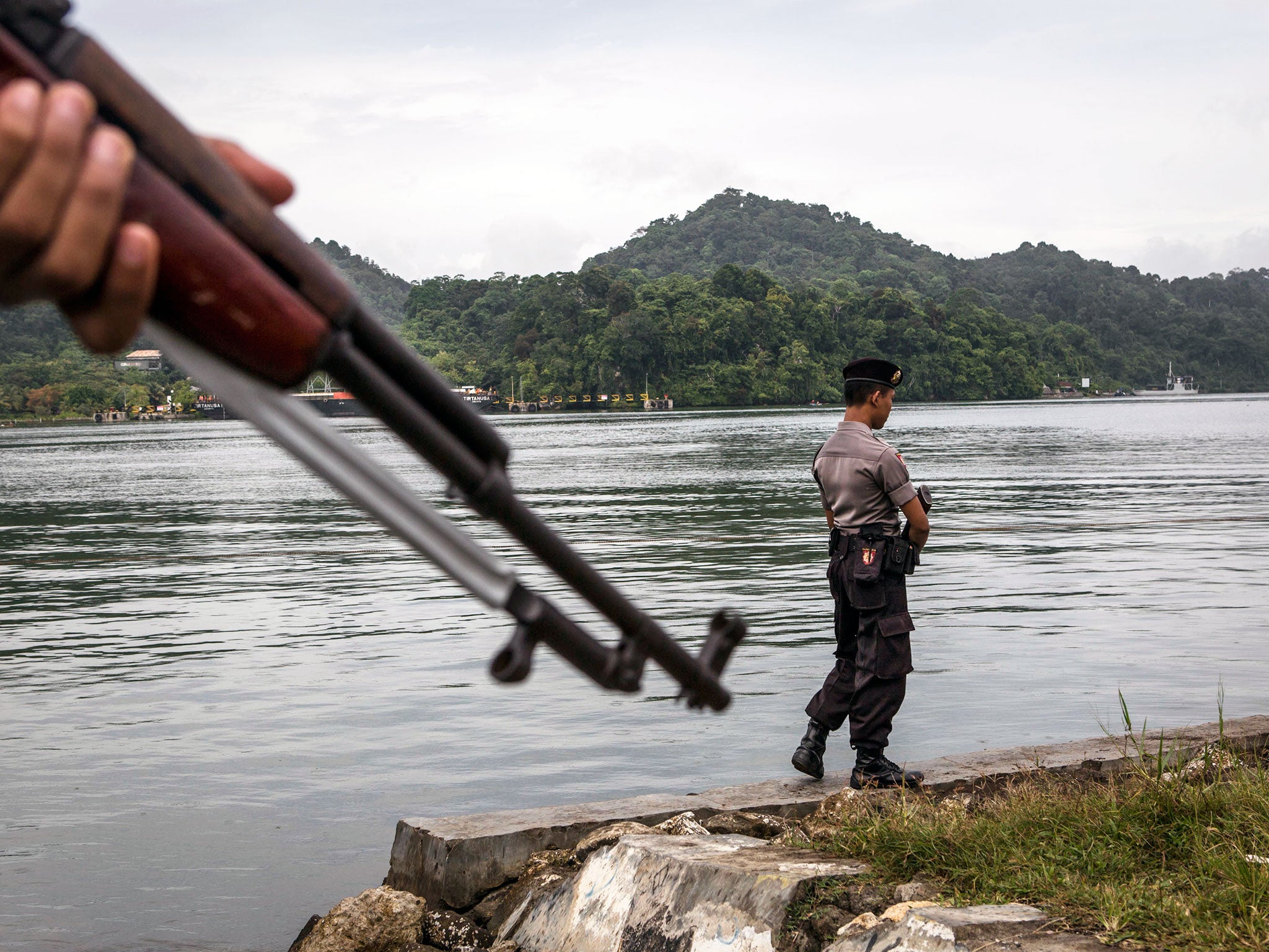 Indonesian police stand guard as the Bali Nine duo Andrew Chan and Myuran Sukumaran arrive at Wijaya Pura Port where they will be transferred to Nusa Kambangan prison ahead of their execution in Cilacap, Central Java, Indonesia