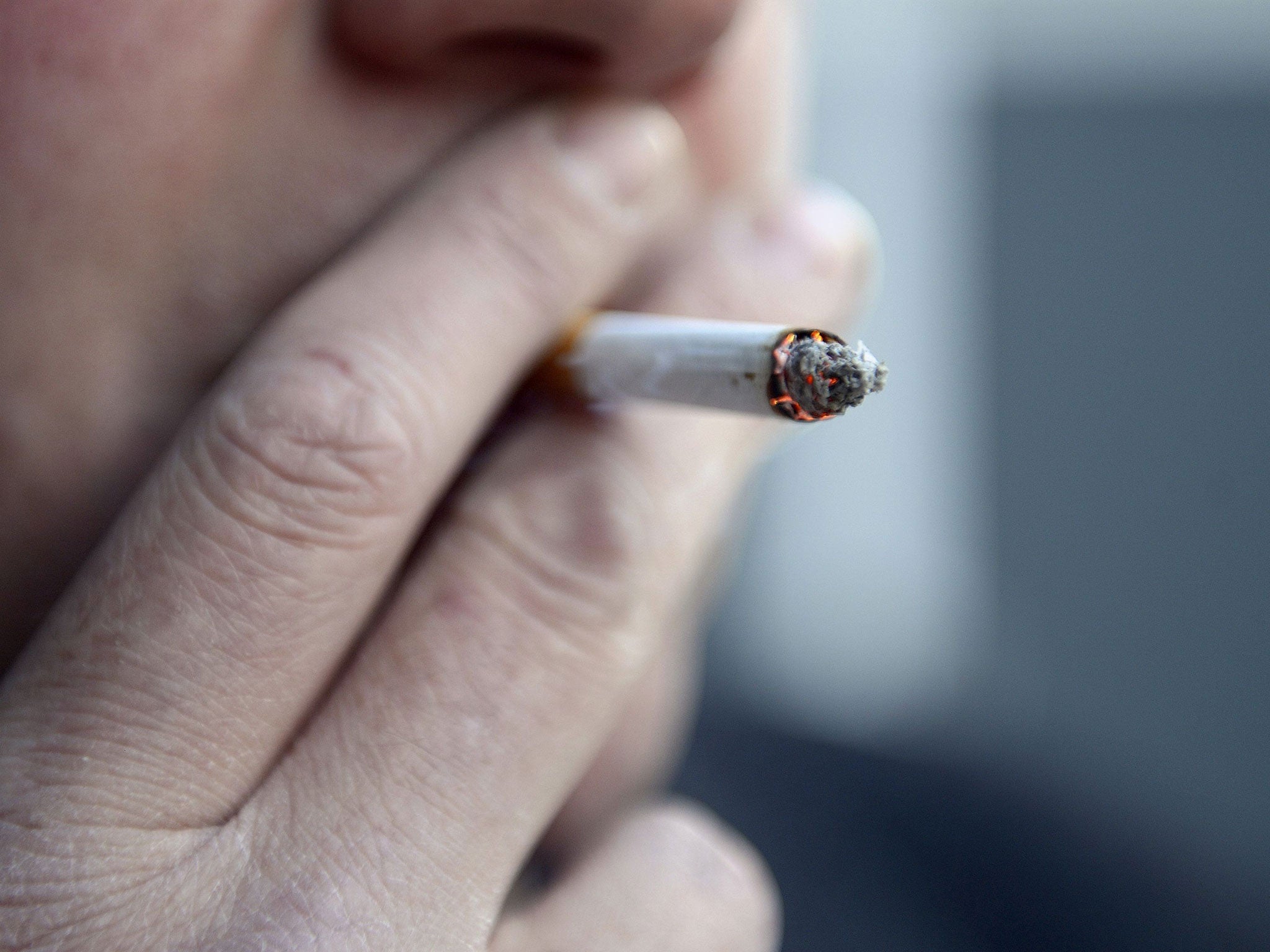 File photo of a man smoking a cigarette, as a prisoner won a landmark ruling that the ban on smoking in public places applies to state prisons and all Crown premises