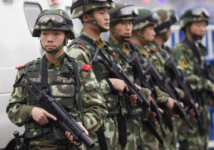 Armed paramilitary policemen stand guard in front of the Guangzhou Railway Station after the knife attack