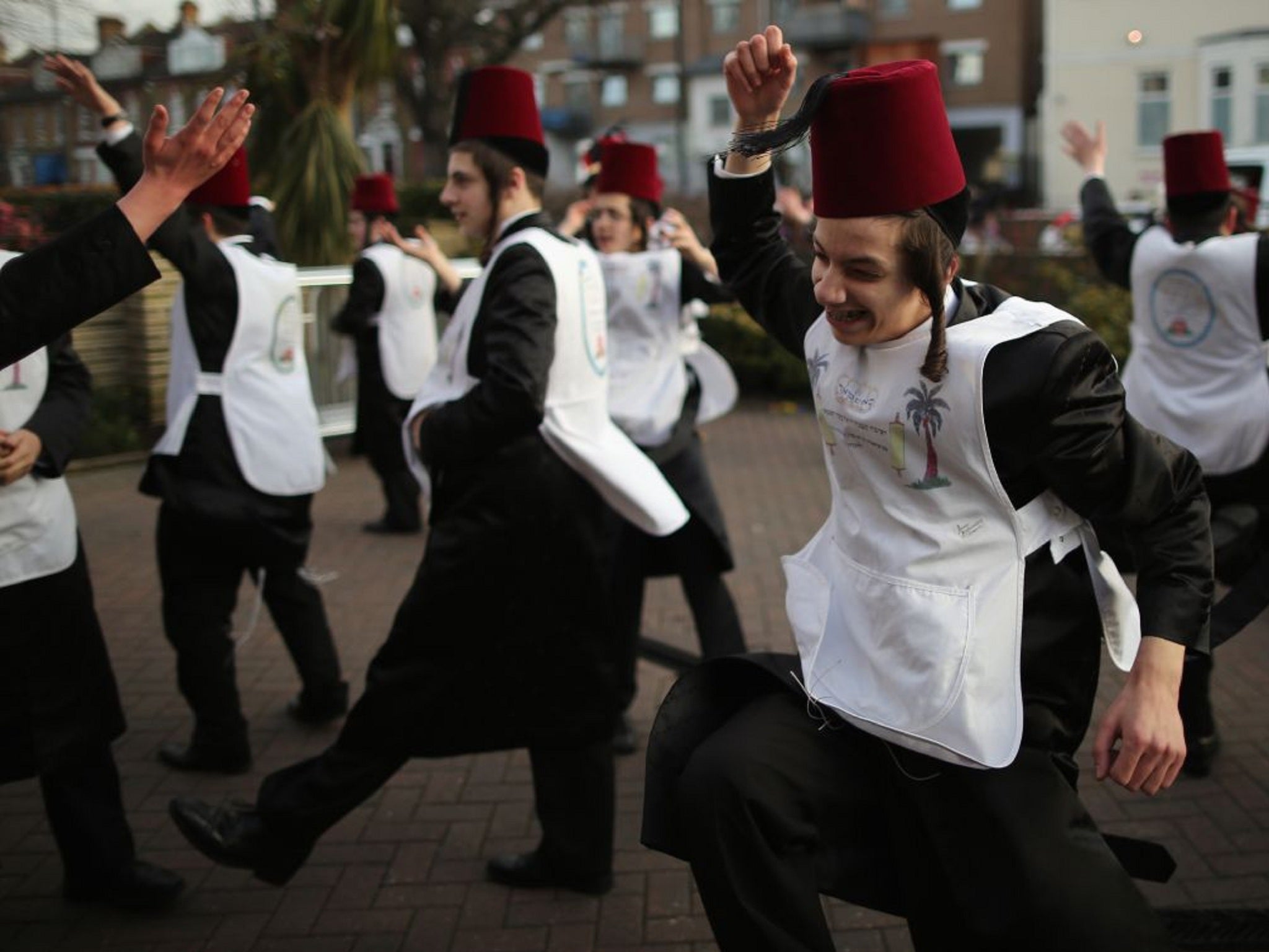 A group of boys dance in the street in London while fundraising for their school