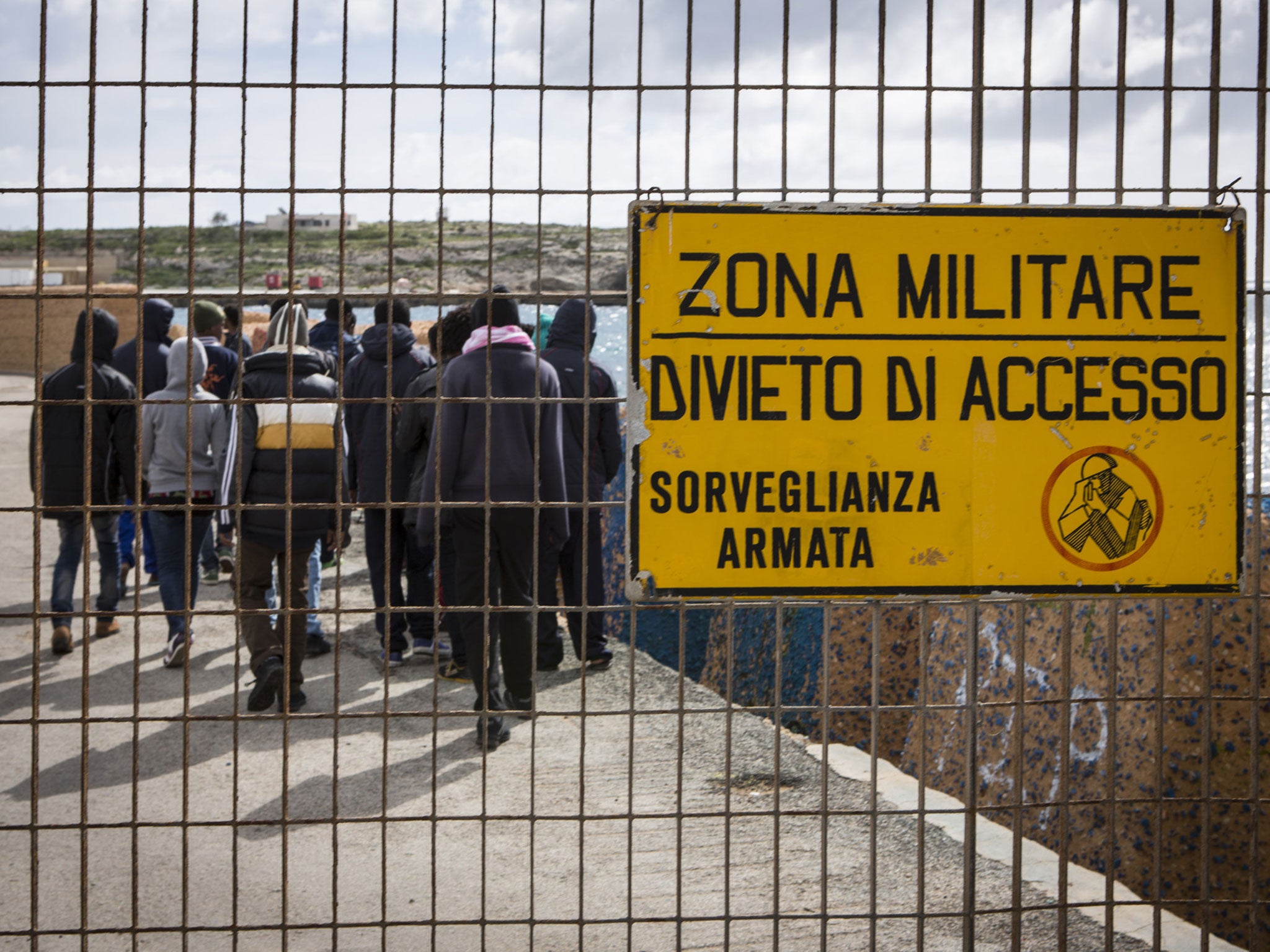 Eritrean migrant teenagers walk to the military zone of the docks of Lampedusa, Italy