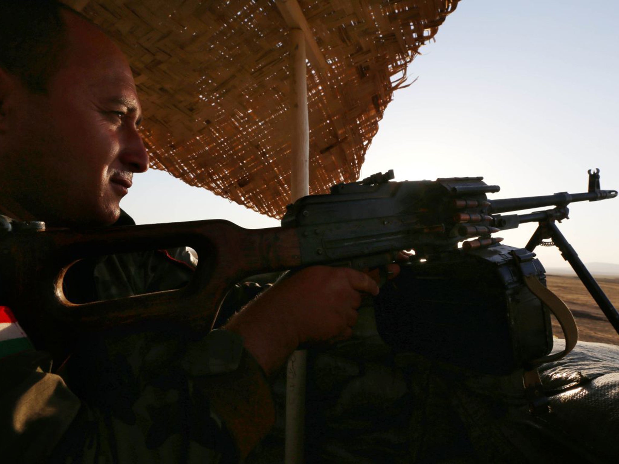 Firing line: a Peshmerga fighter mans a checkpoint to the west of Irbil