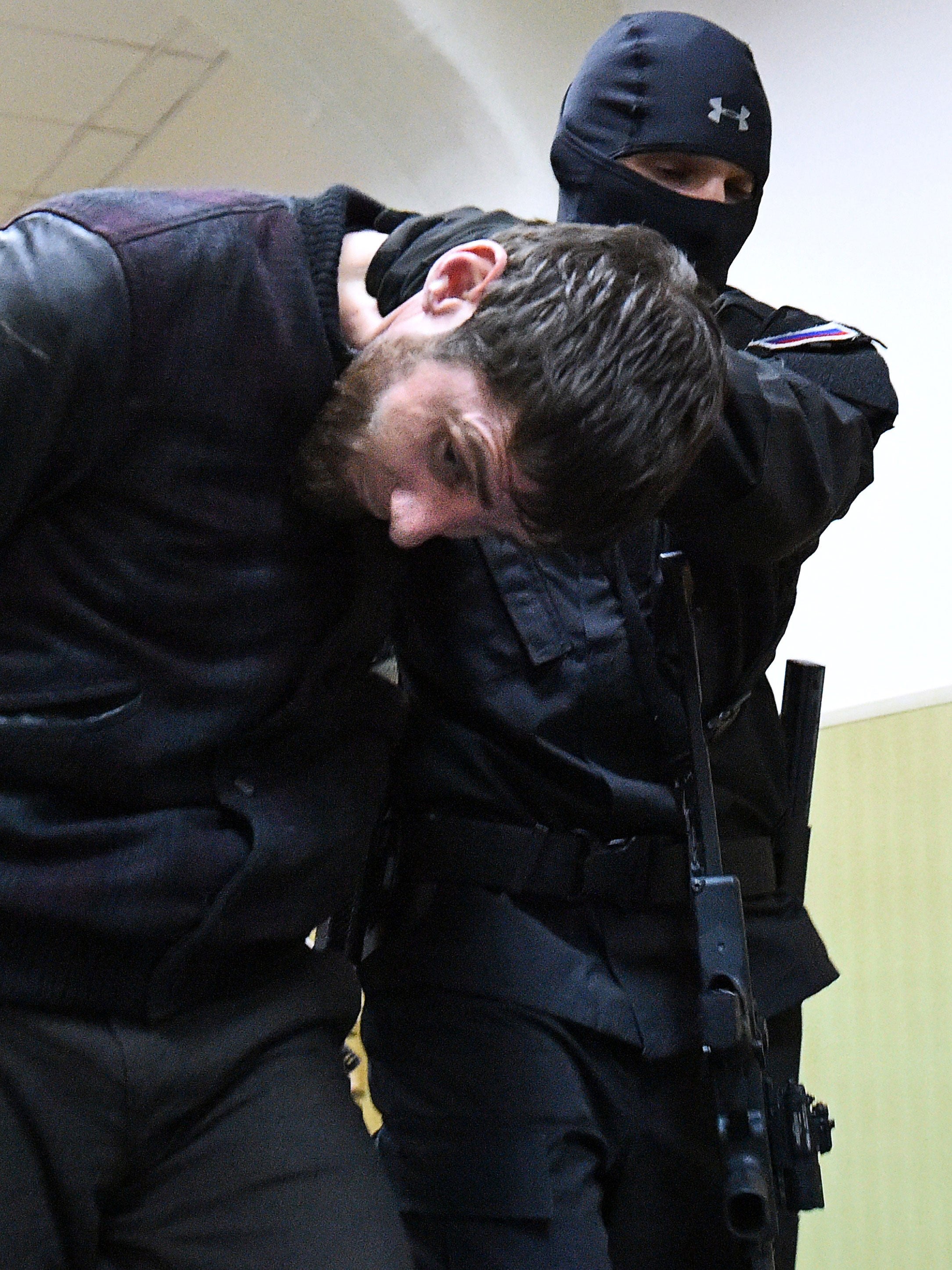 Zaur Dadayev is escorted by a policeman at the Basmanny district court in Moscow