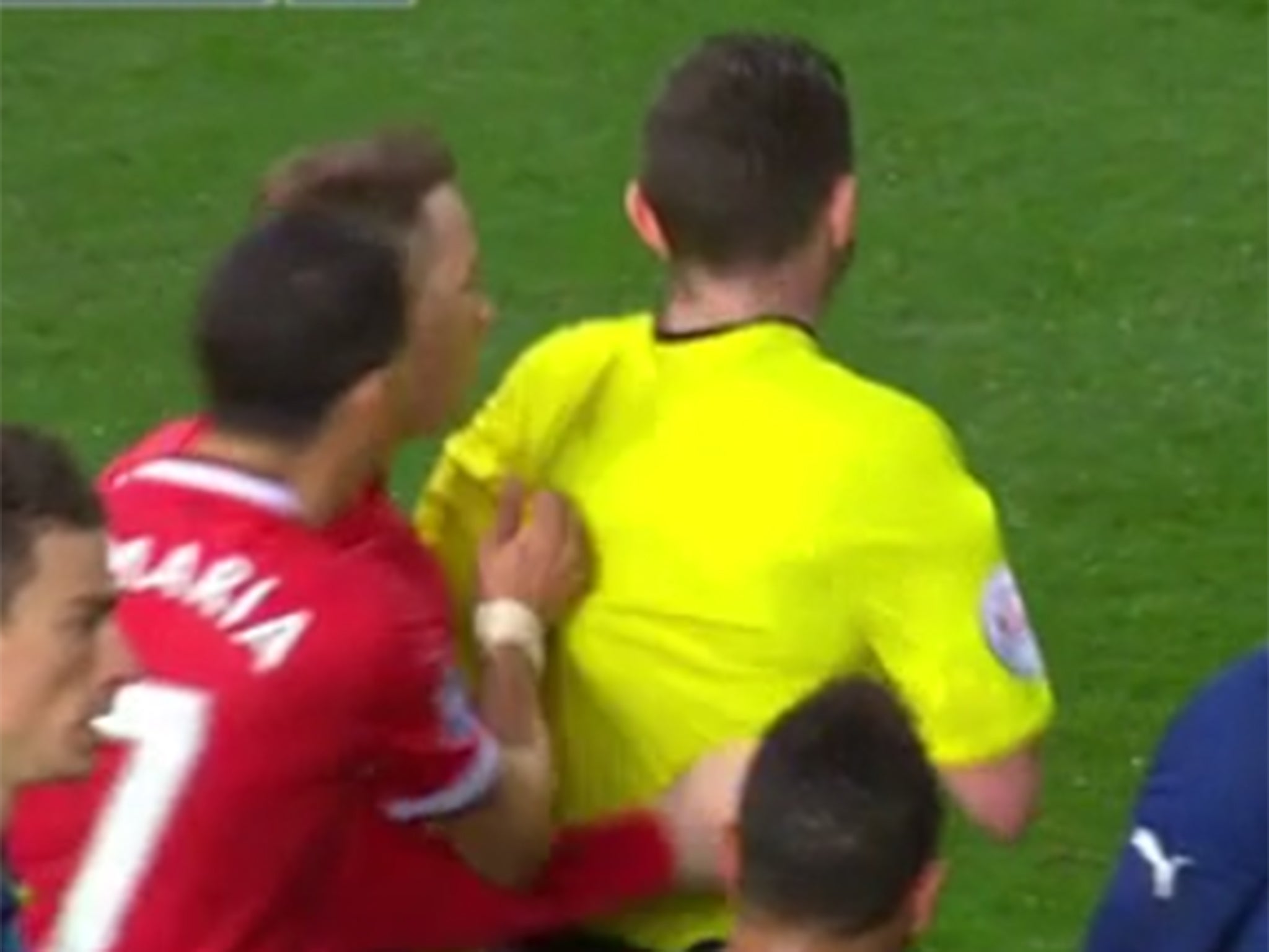 Angel Di Maria pulls at the shirt of the official