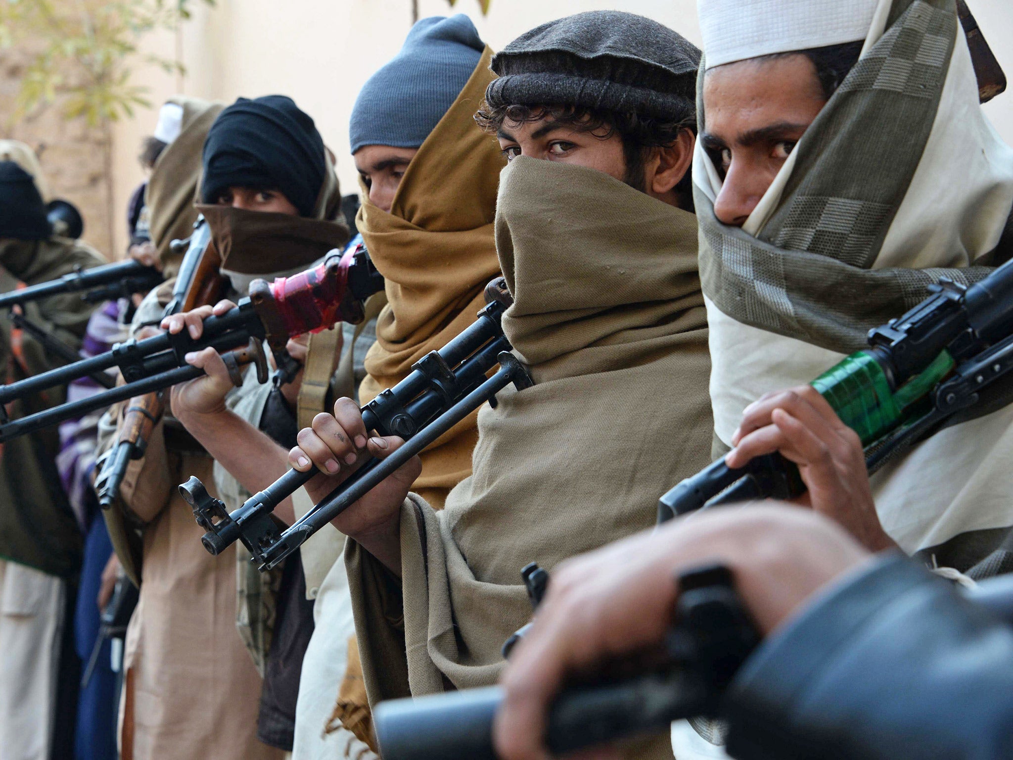 Former Taliban fighters are photographed holding weapons before they hand them over as part of a government peace and reconciliation process at a ceremony in Jalalabad last month