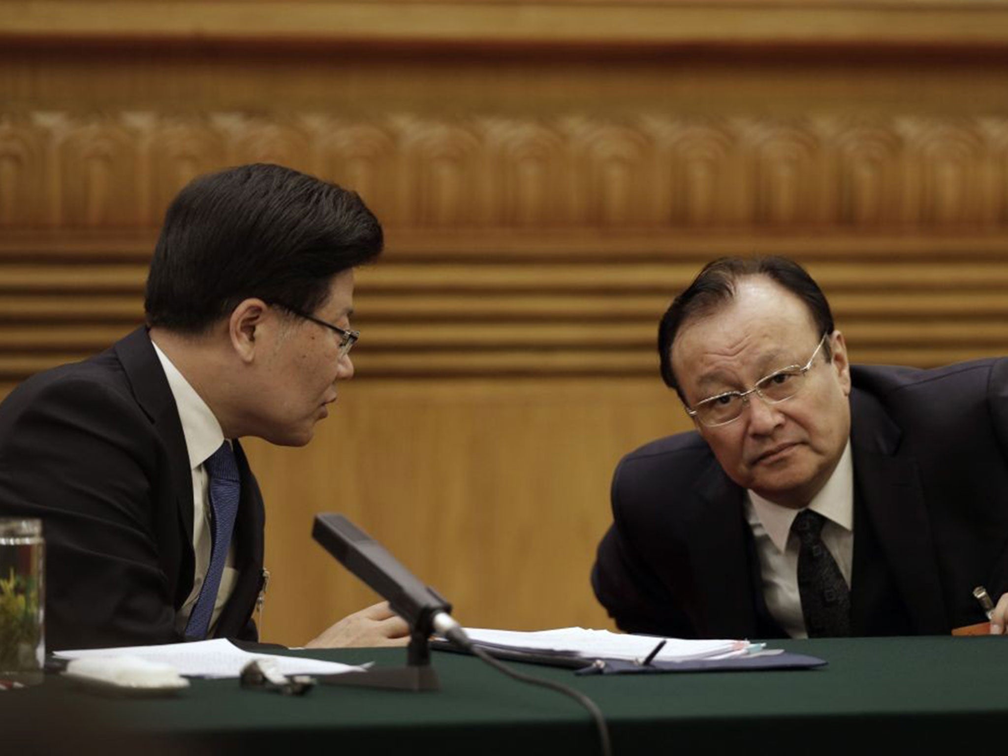 Communist Party Secretary of Xinjiang, Zhang Chunxian, left, talks with Shohrat Zakir, chairman of the Xinjiang Uyghur Autonomous Region, during thier delegation's meeting on the sideline of the National People's Congress