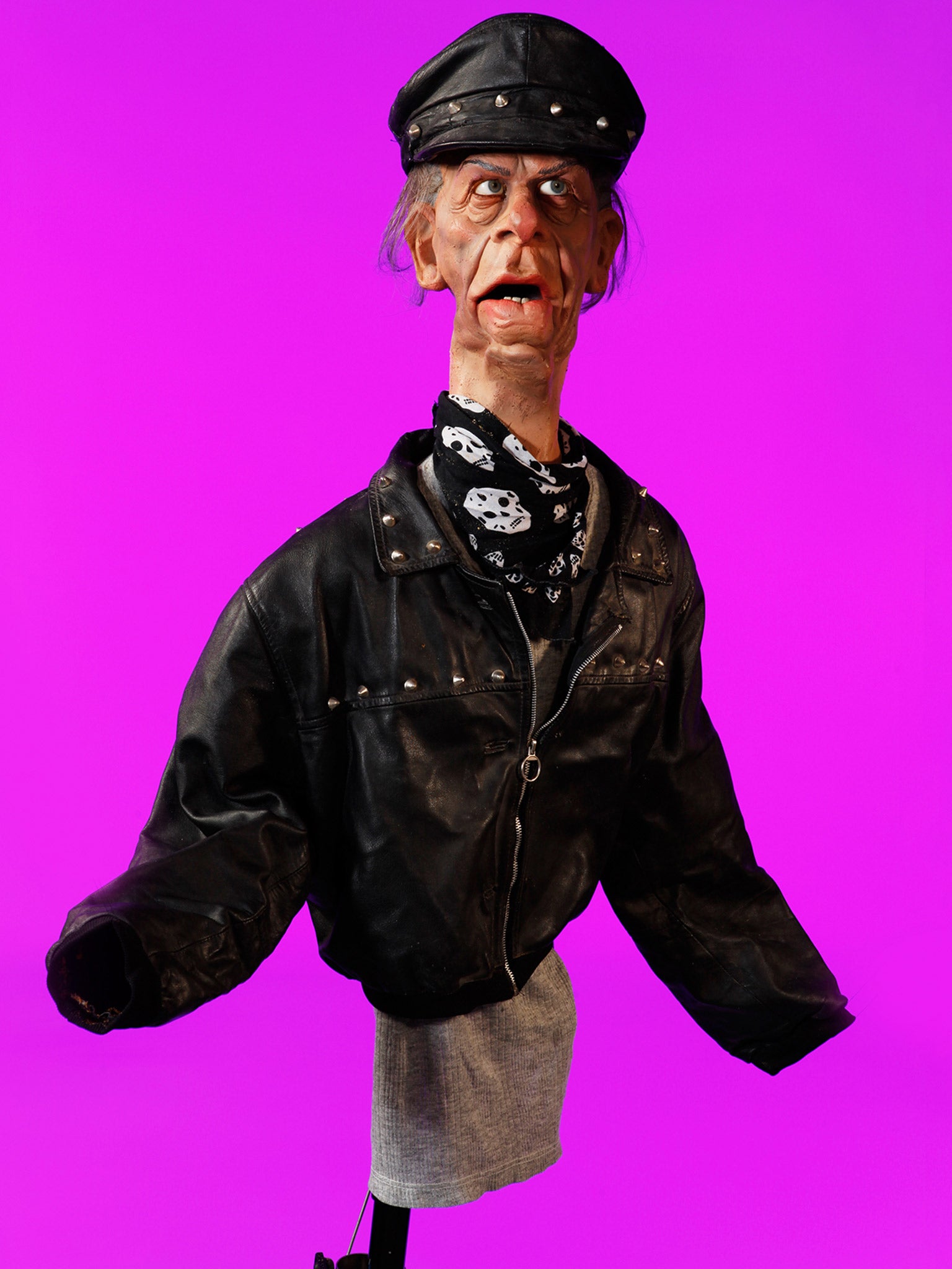 The vivid pink photograph of Norman Tebbit, who was portrayed in the show as a bully and a thug, shows him wearing a biker jacket and leather hat (Andrew Bruce & Anna Fox)