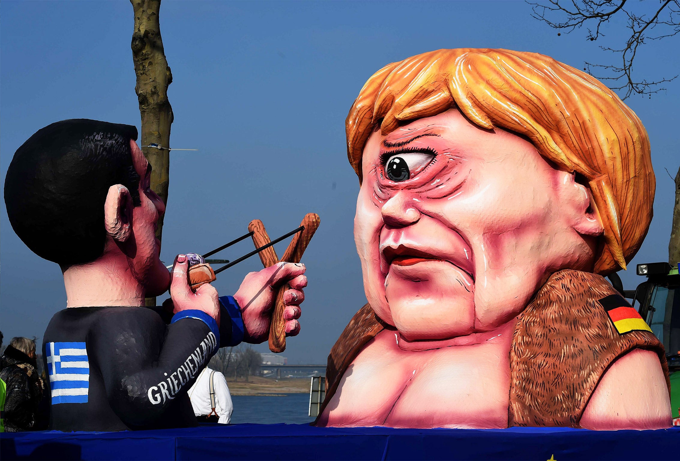 Figures depicting Greek Prime Minister Alexis Tsipras and German Chancellor Angela Merkel during a carnival parade in Duesseldorf last month (Getty)