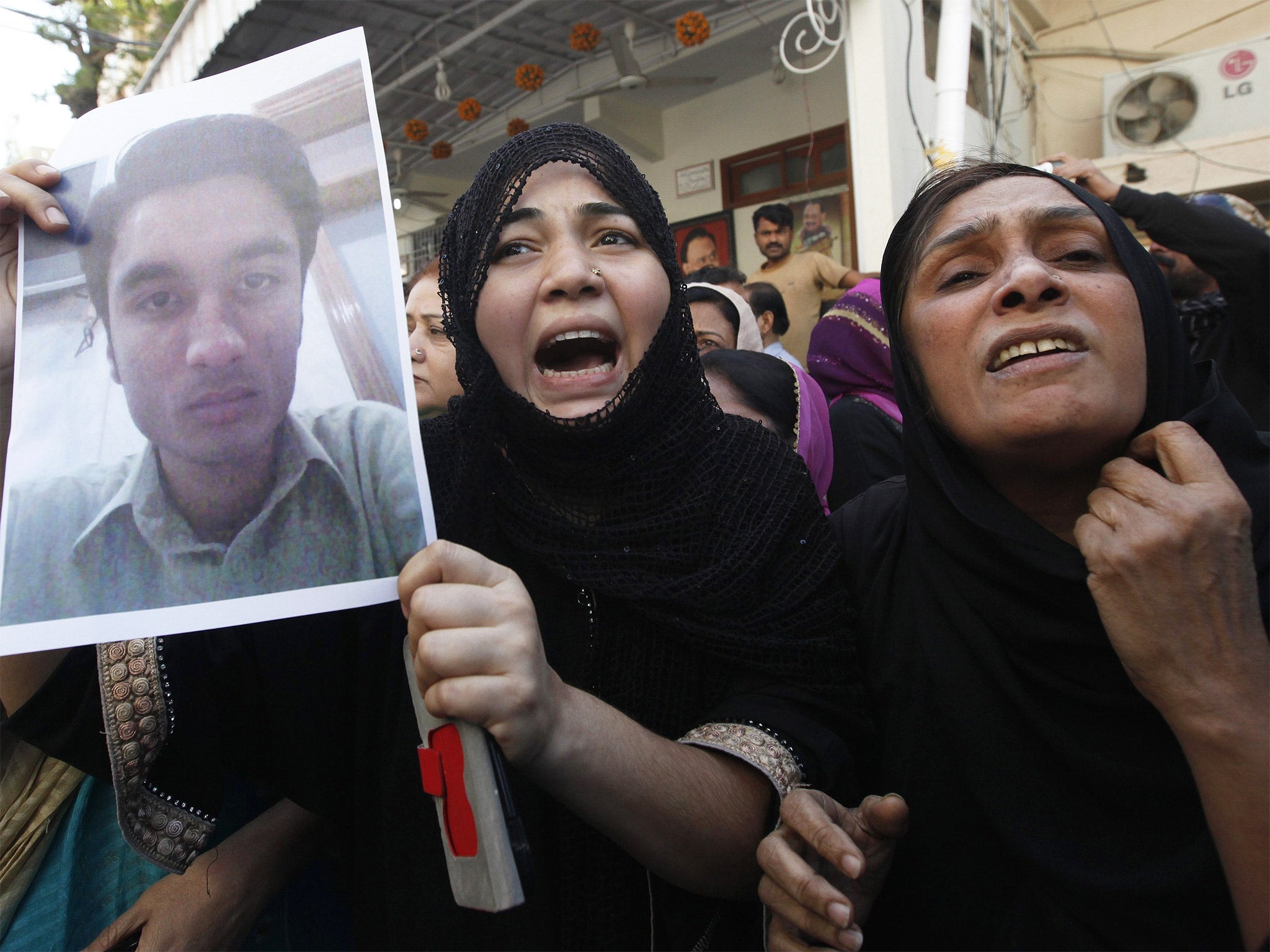 A relative of an MQM supporter who was detained by paramilitary forces during a raid on their headquarters, joins a protest after the incident in which a press officer was killed