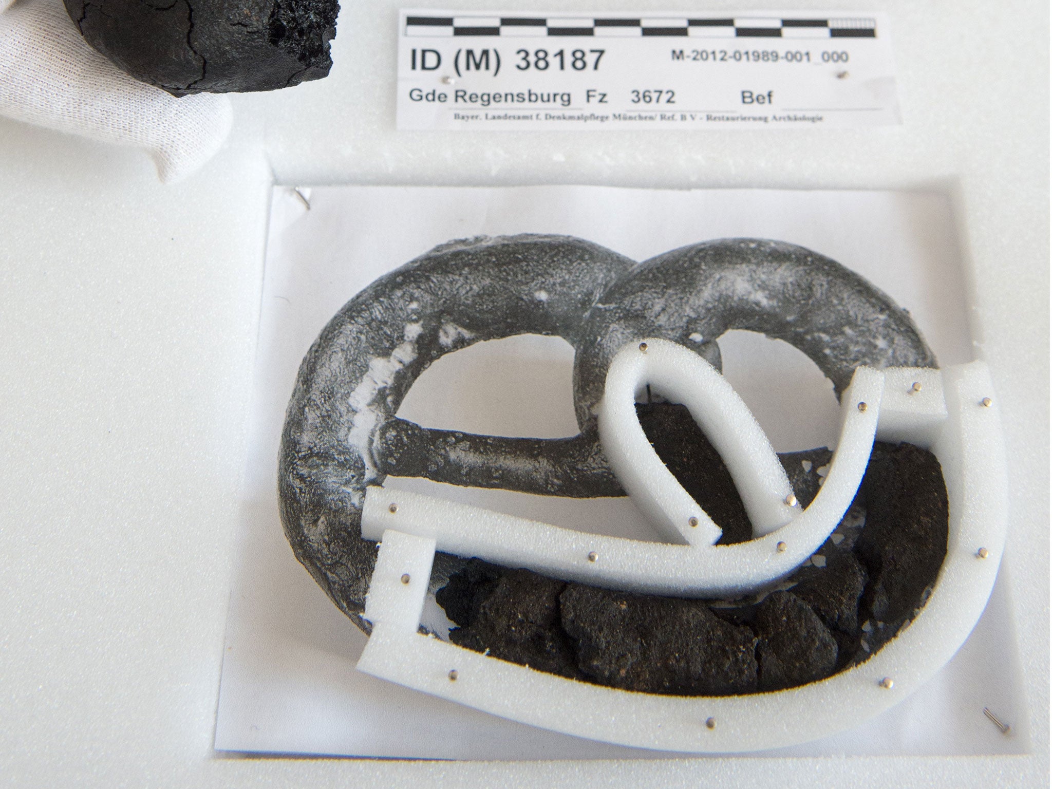 A staff member of the museum presents the remains of 250-year old pretzels and buns at the History Museum in Regensburg.