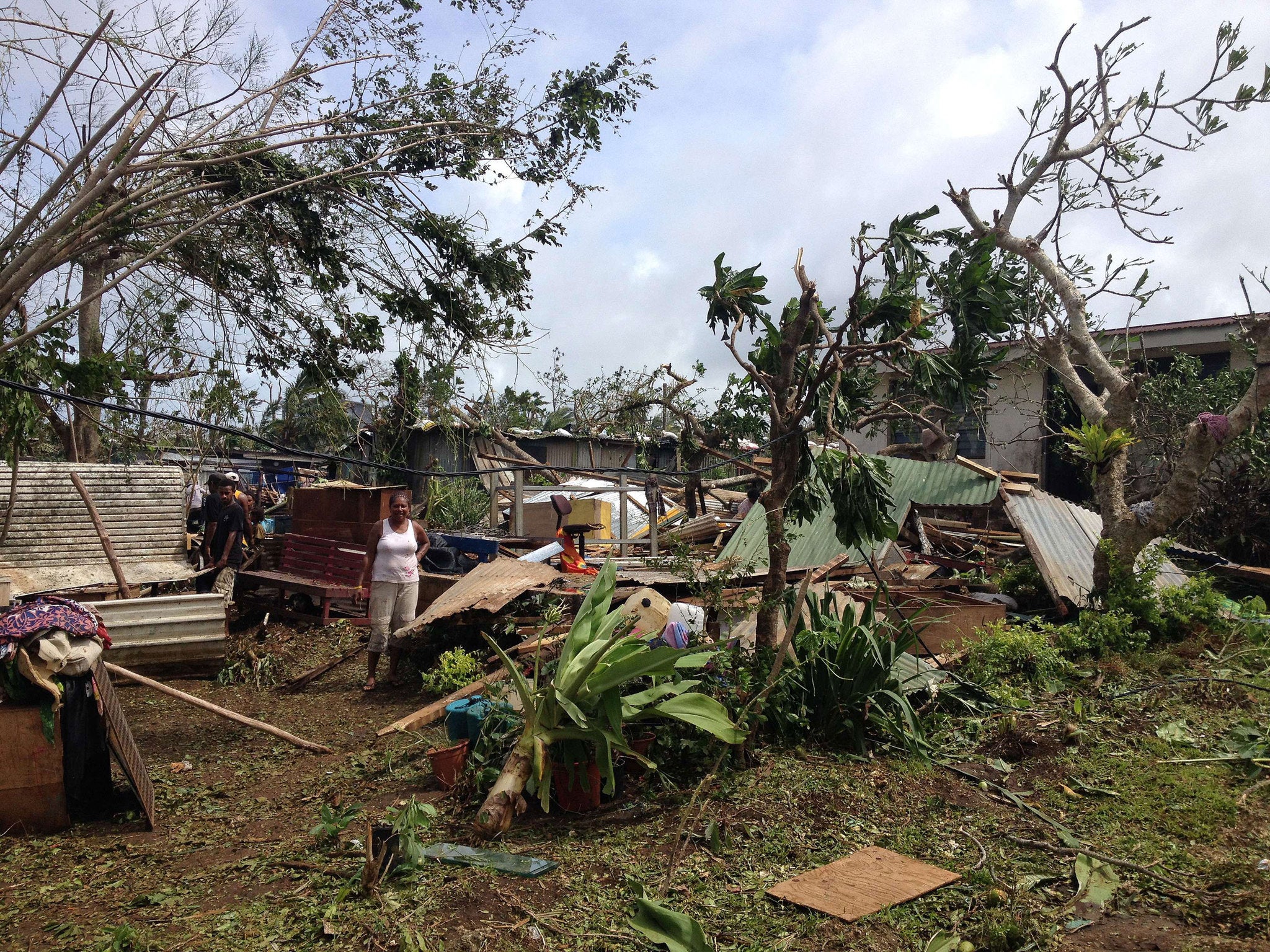 People cleared up debris at their homes near Port Vila