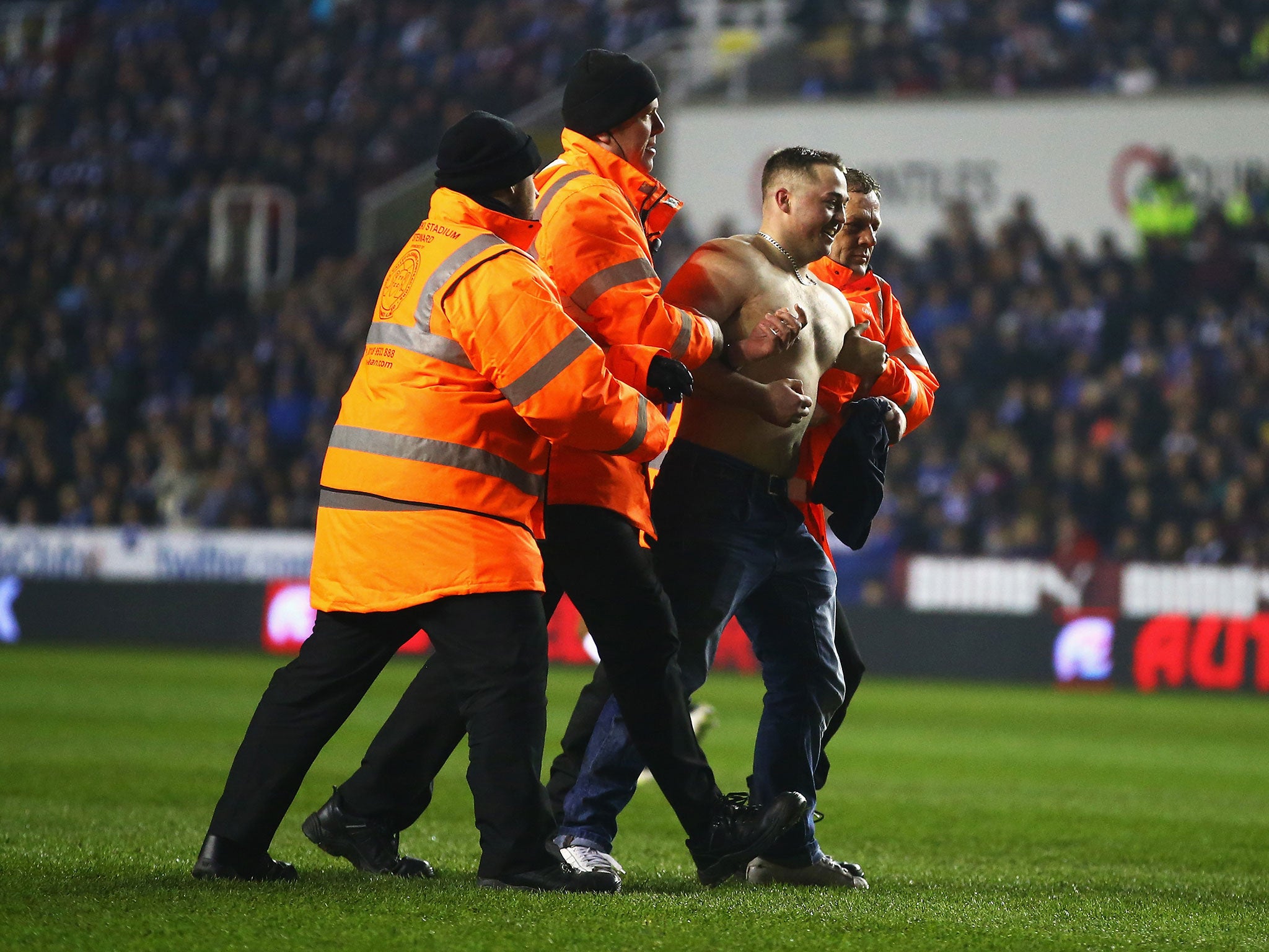 Stewards eventually lead the pitch invader away