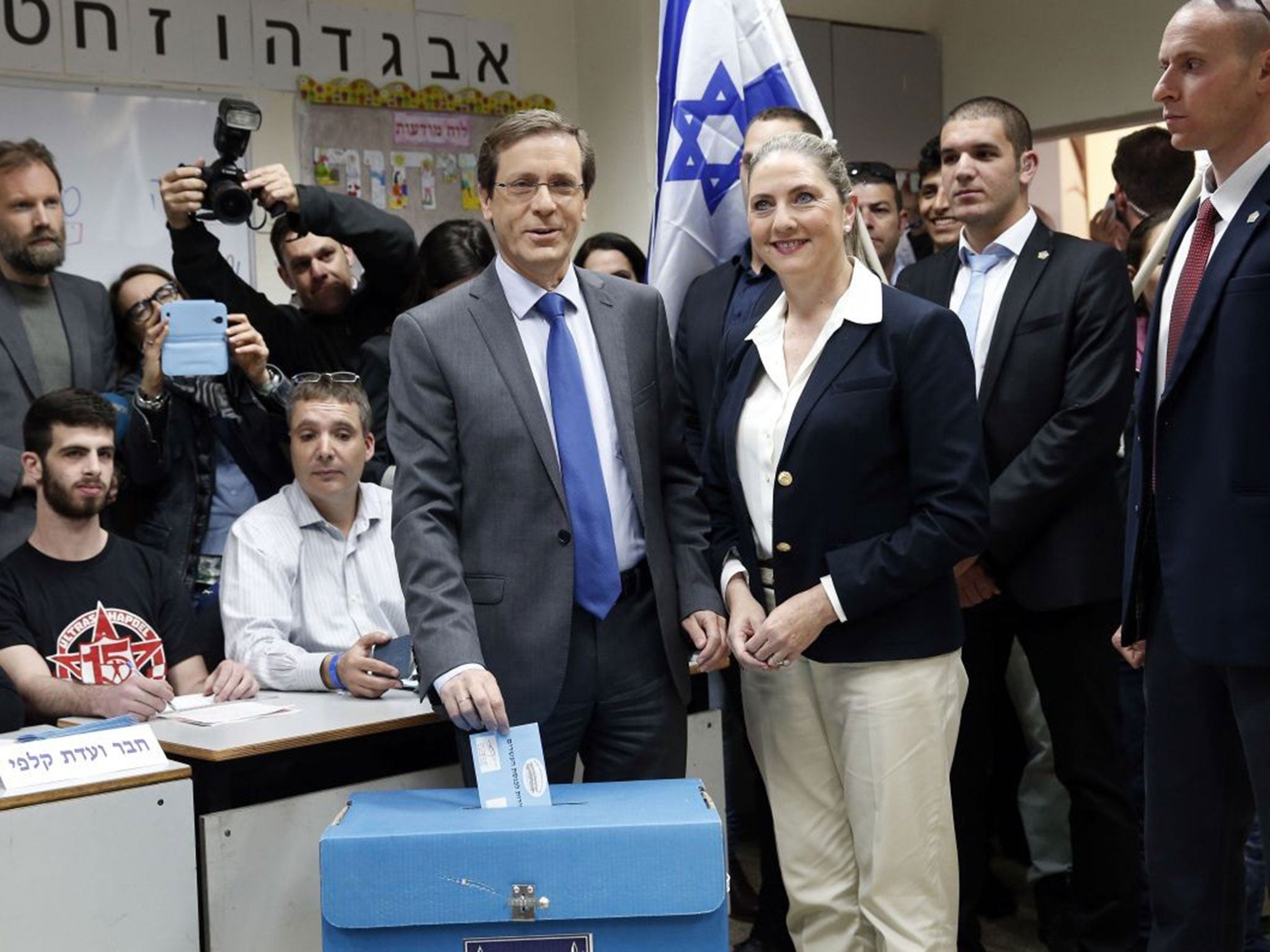 Israeli Labour Party leader and co-leader of the Zionist Union list for the upcoming general election, Isaac Herzog (C), casts his ballot