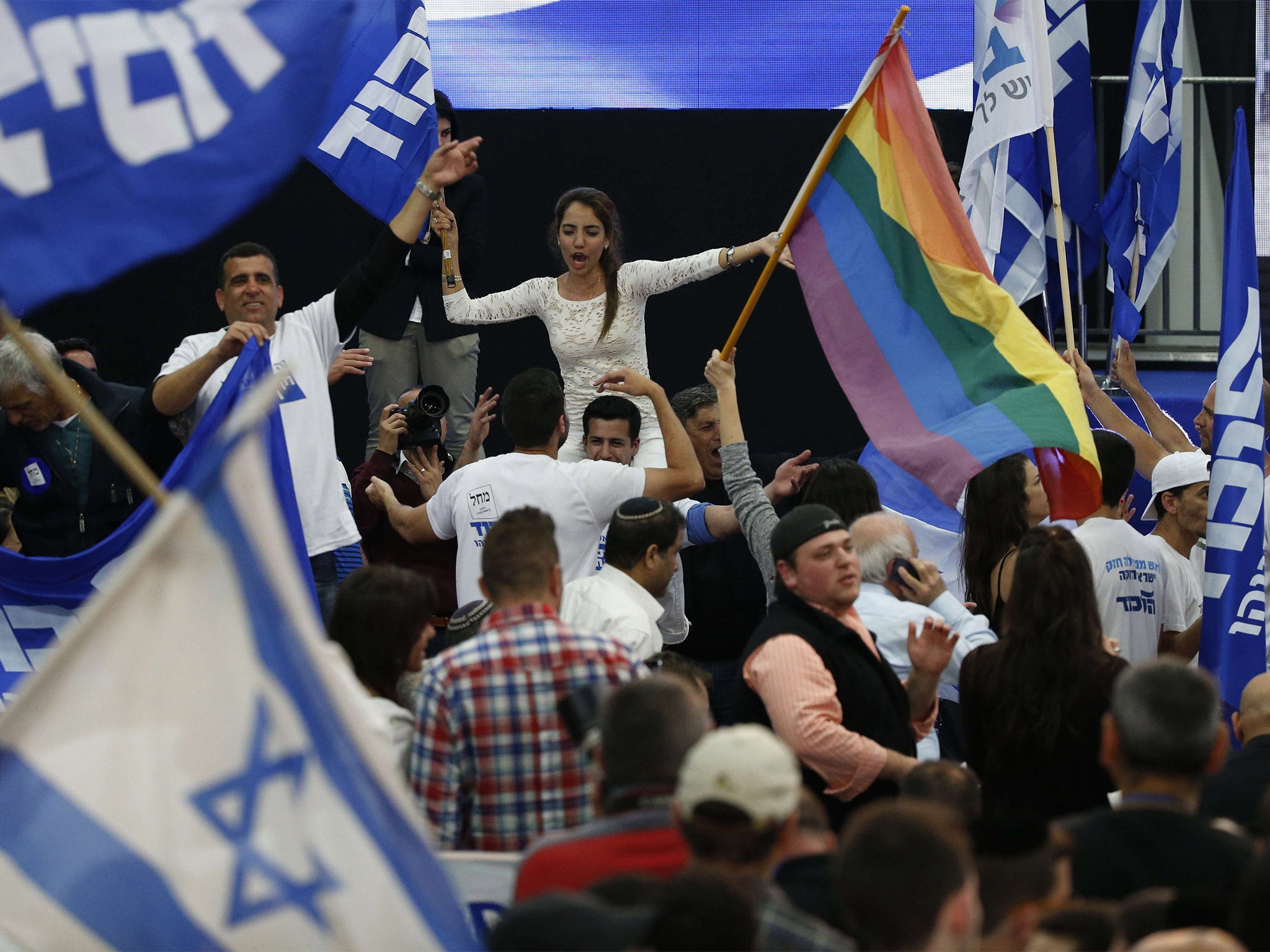 Supporters of Israeli Prime Minister Benjamin Netanyahu's Likud party react to exit poll figures