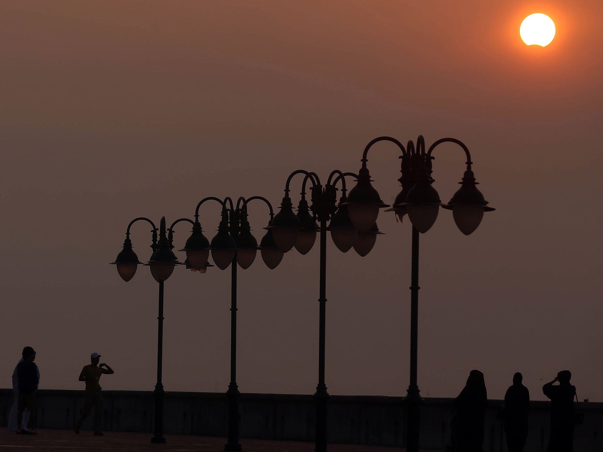 Kuwaitis watch a partially solar eclipse at Souq Sharq Marina in Kuwait City