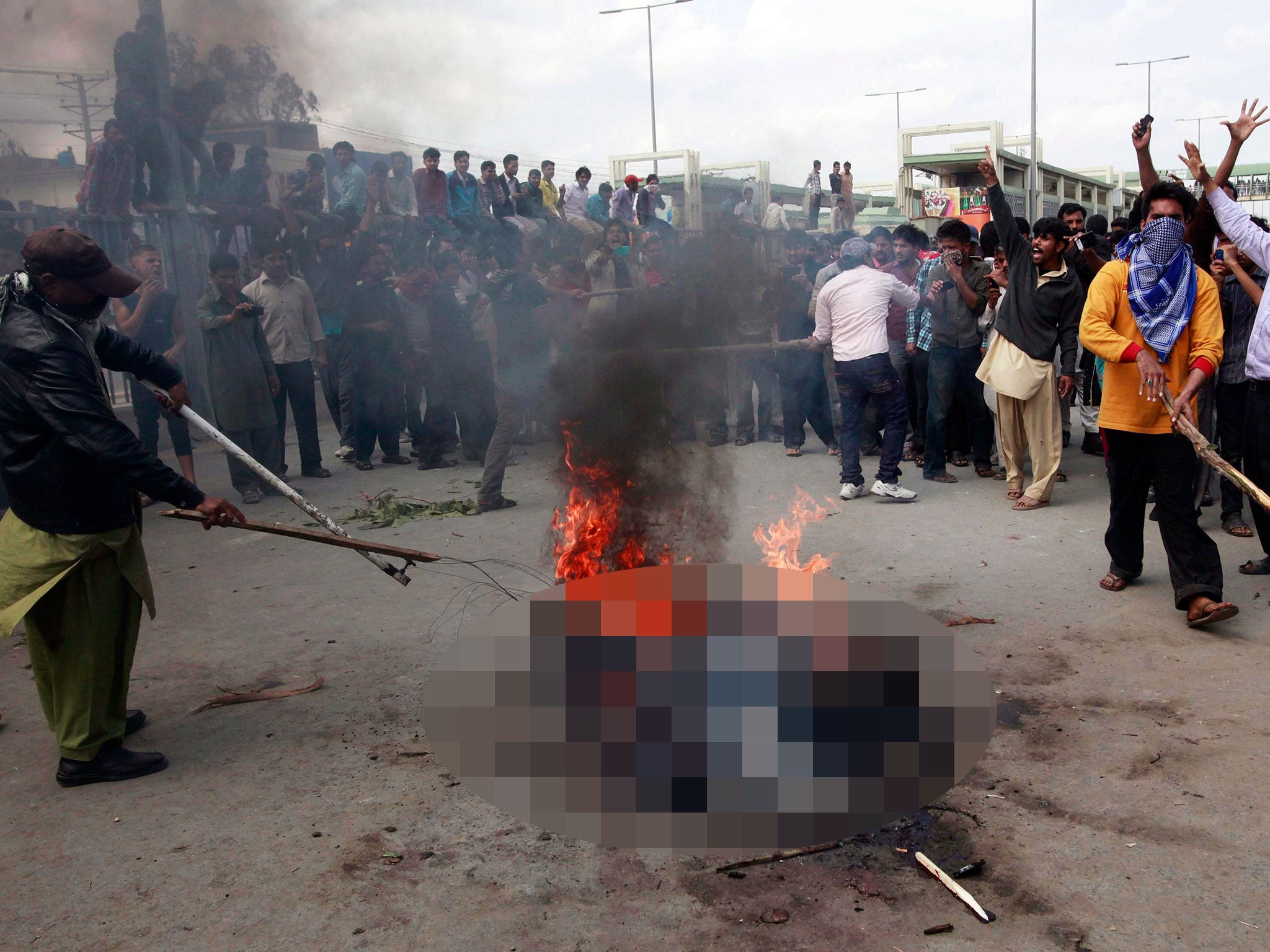 Enraged Christians residents burn men they suspected of being involved in bomb attacks on churches, after lynching them in Lahore