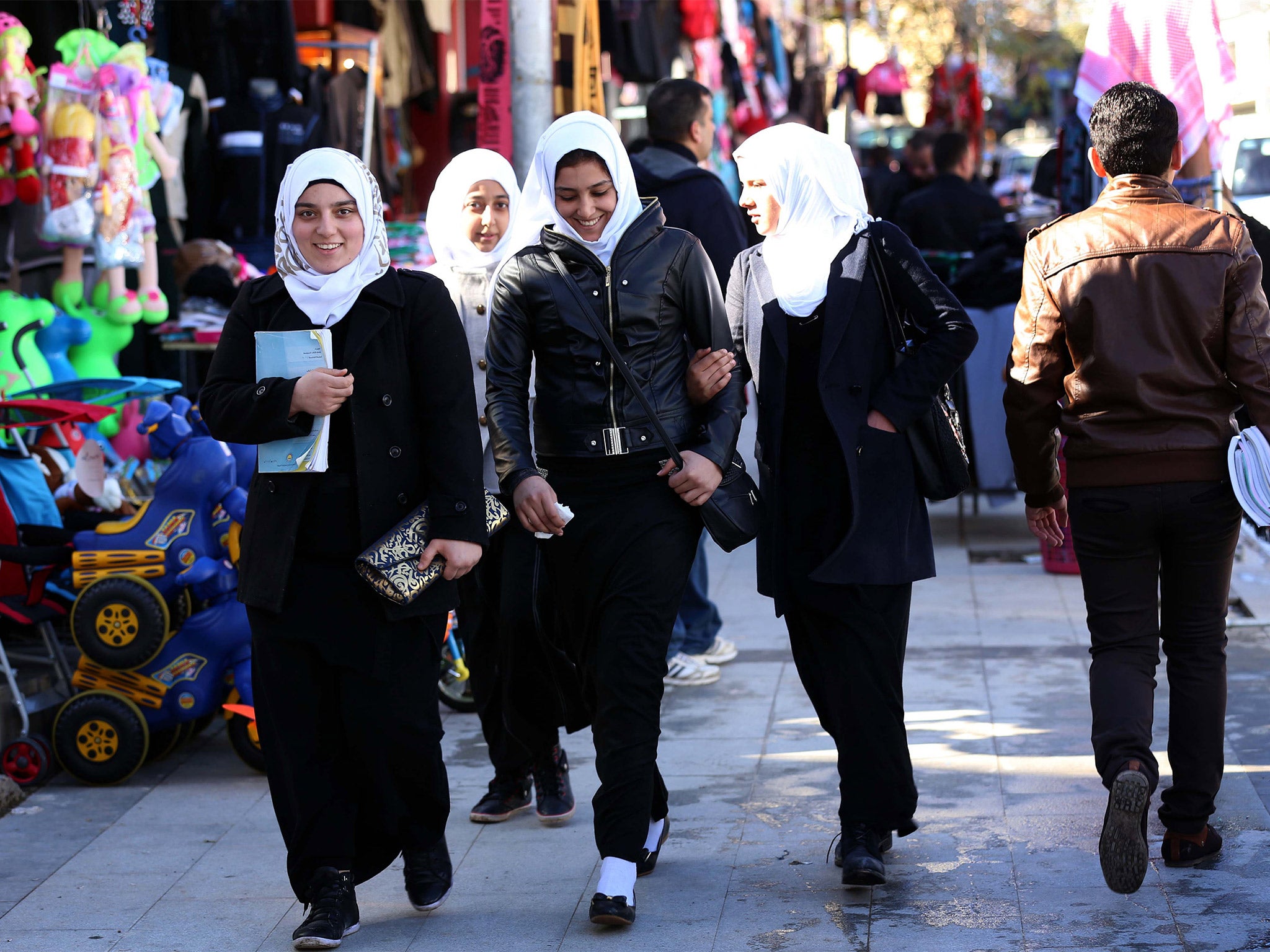 Displaced Iraqi Sunni Muslim girls, who fled their hometown of Fallujah due to unrest between government forces and militants, walk in the Kurdish town of Shaqlawa (Getty)