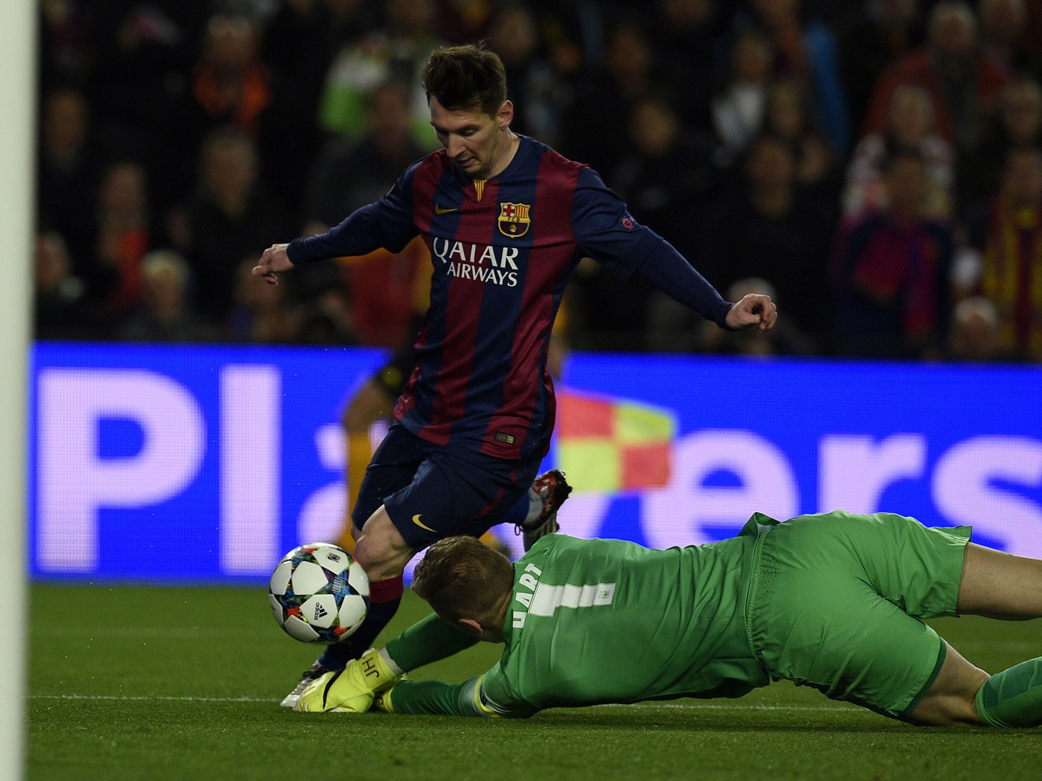 Joe Hart dives at the feet of Lionel Messi to save a shot