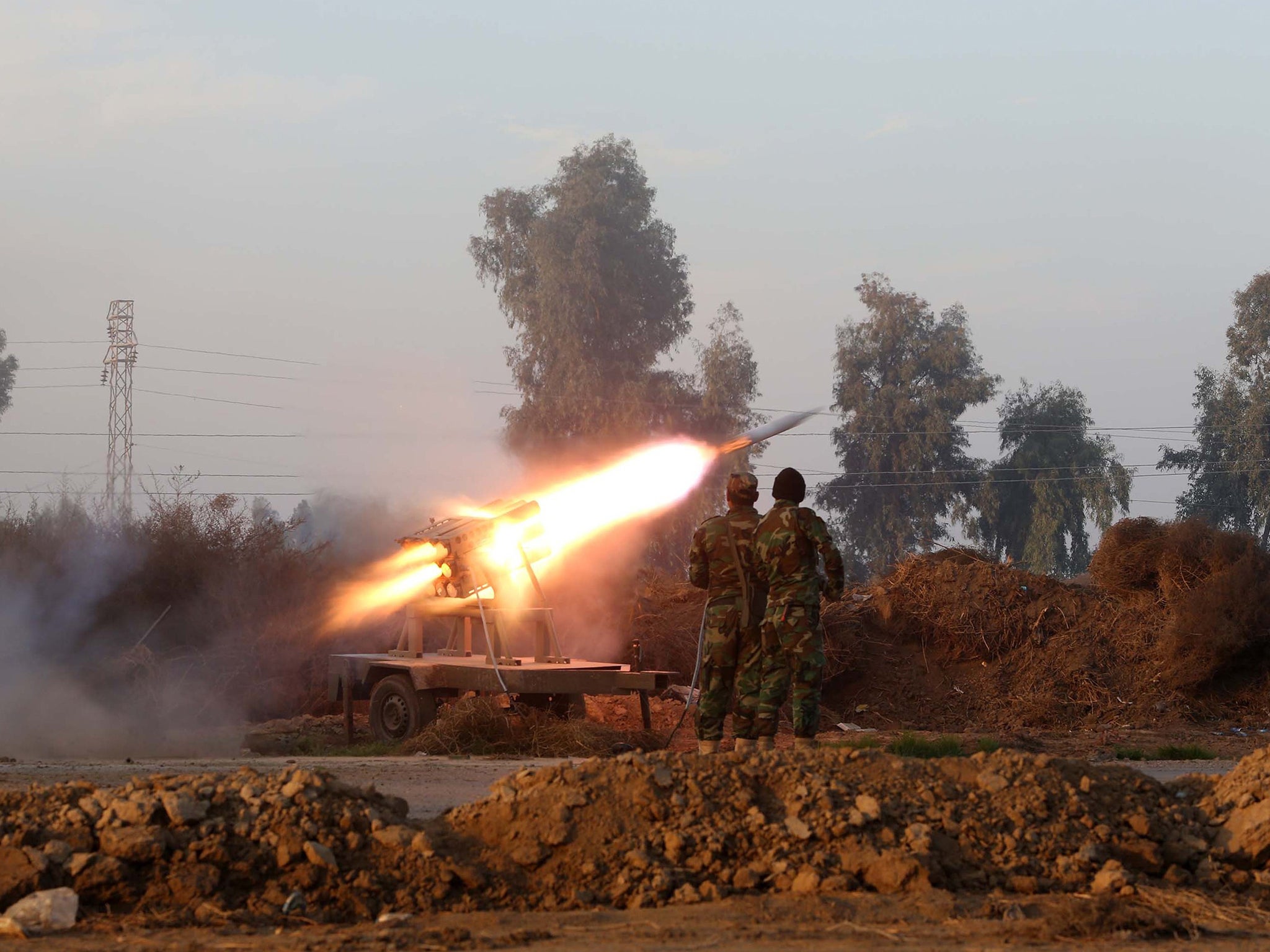 Iraqi soldiers launch a rocket during clashes with Islamic State