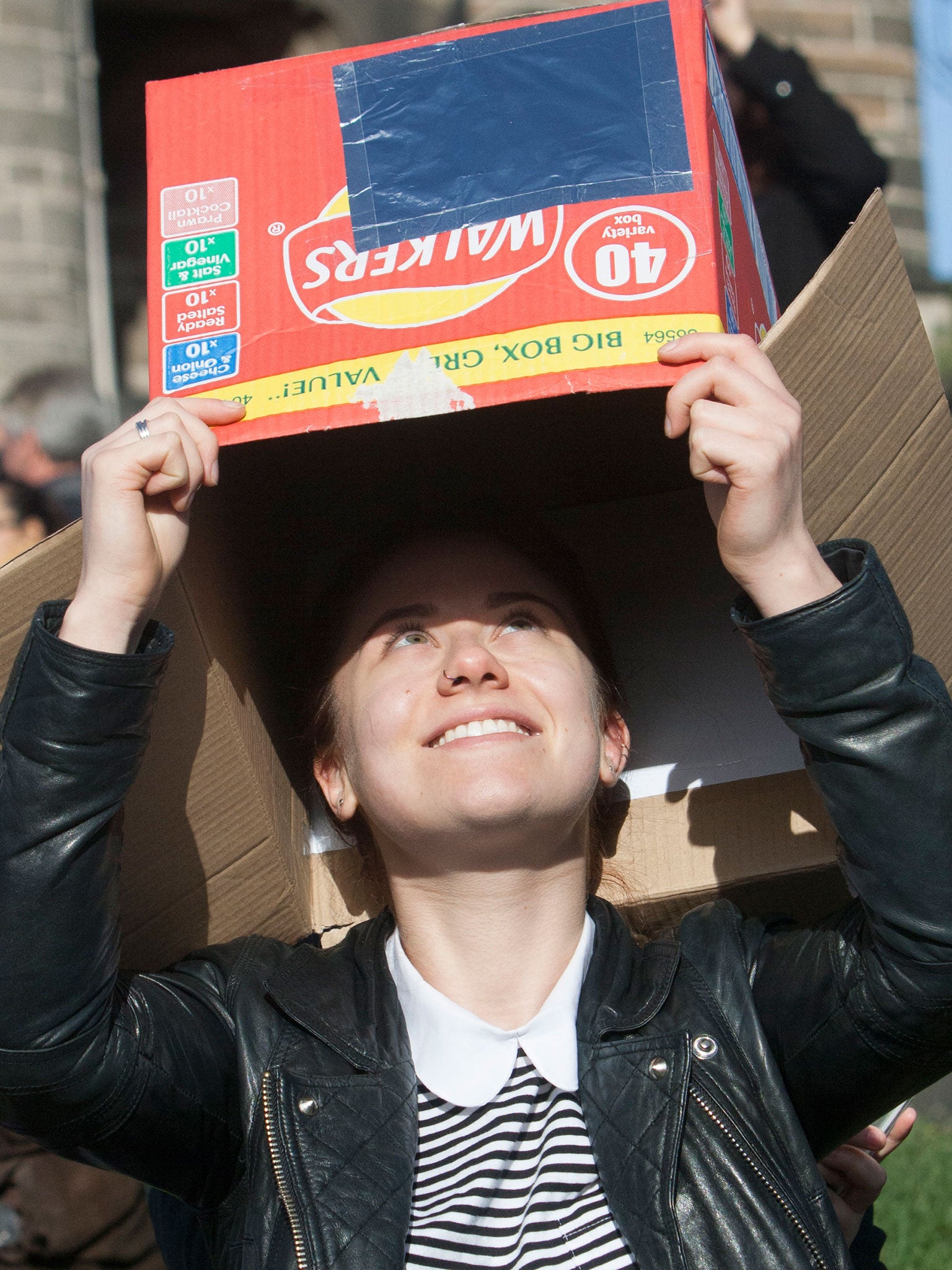 A woman views the solar eclipse from Carlton Hill in Edinburgh