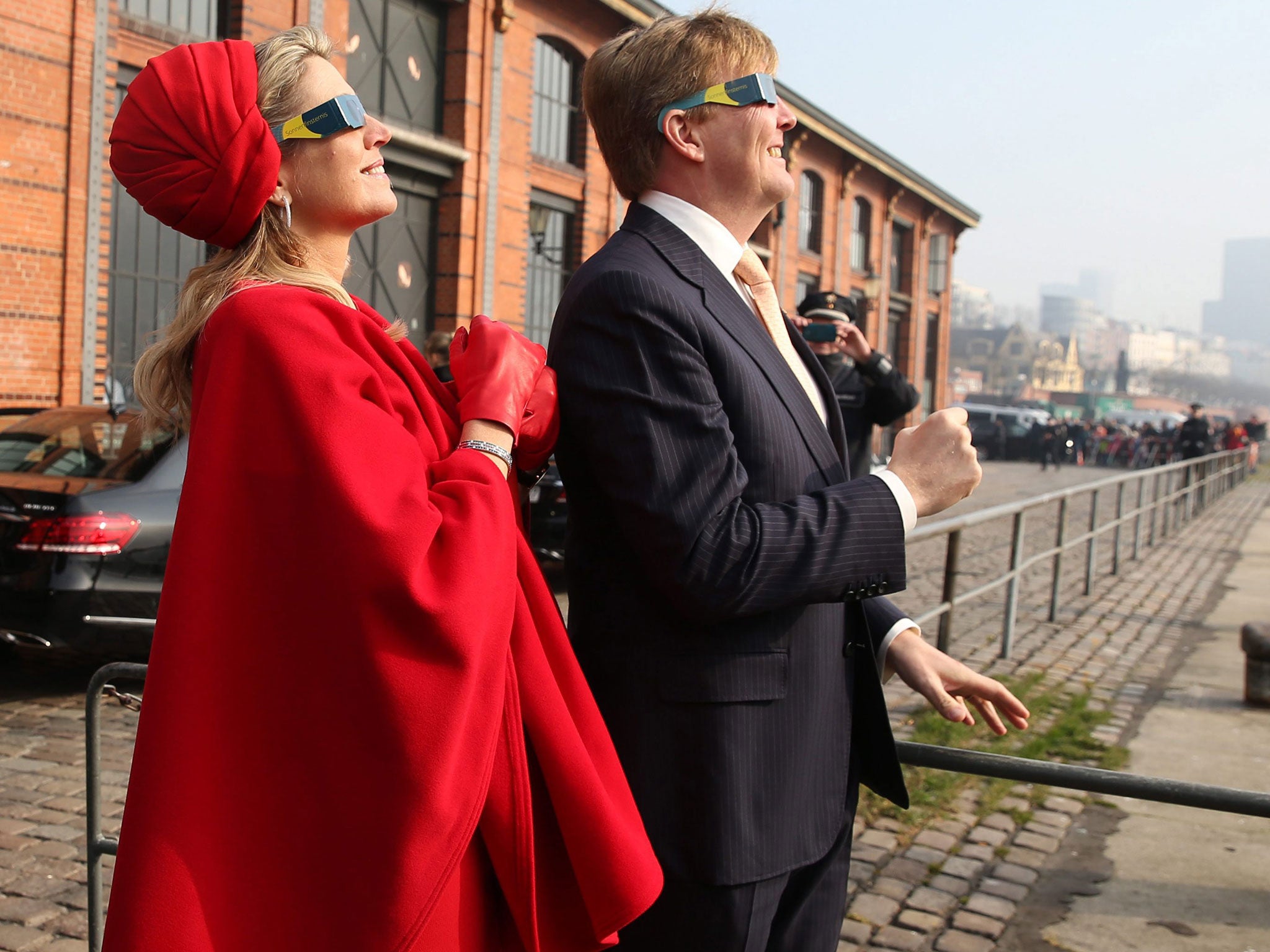 Queen Maxima and King Willem-Alexander of the Netherlands look at the solar eclipse through special glasses at the Fish Market in Hamburg, Germany