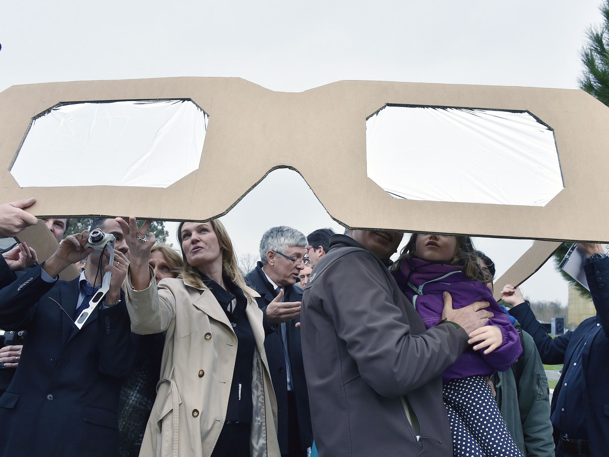 People use giant protective glasses to watch a solar eclipse at the Cite de l'Espace (Space City) in Toulouse, France