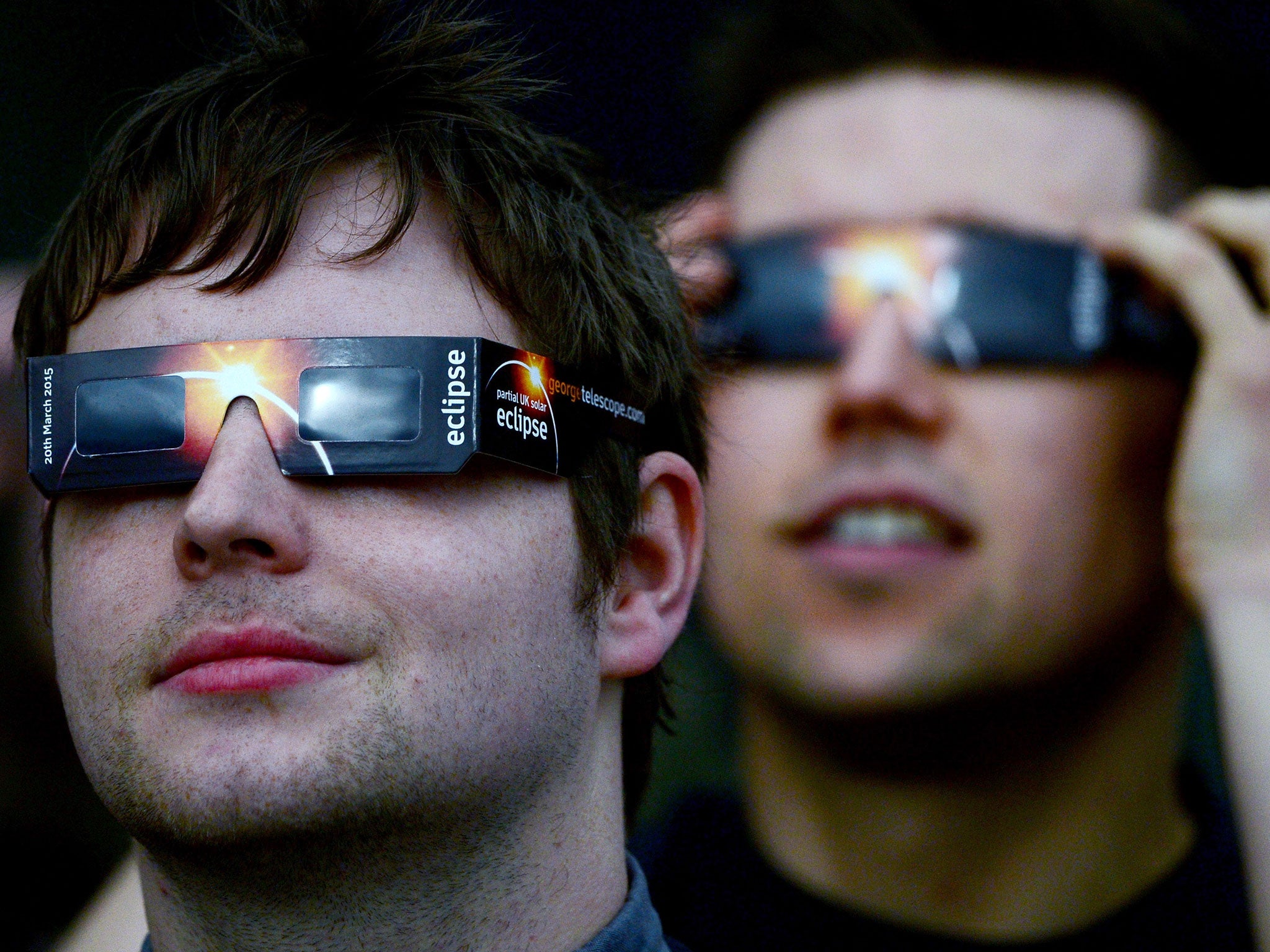 Members of the public use protective glasses to look into the sky at a partial solar eclipse on March 20, 2015 in Glasgow