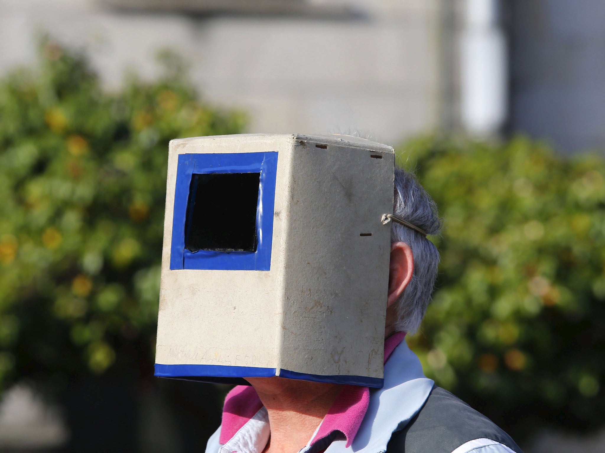 A man uses a special solar visor to watch the eclipse