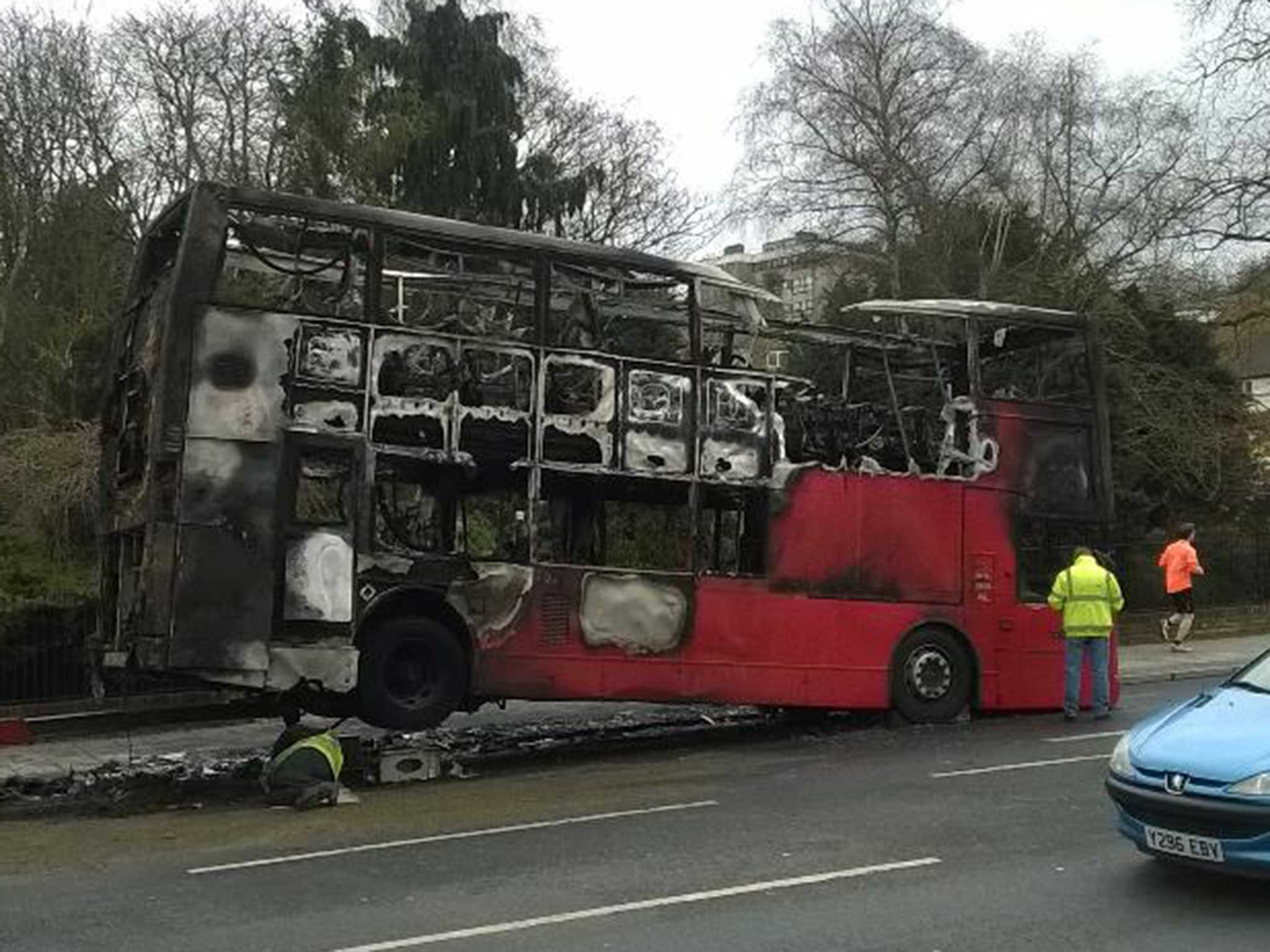 The damaged bus is inspected after the area is cordoned off (Lester Ford)