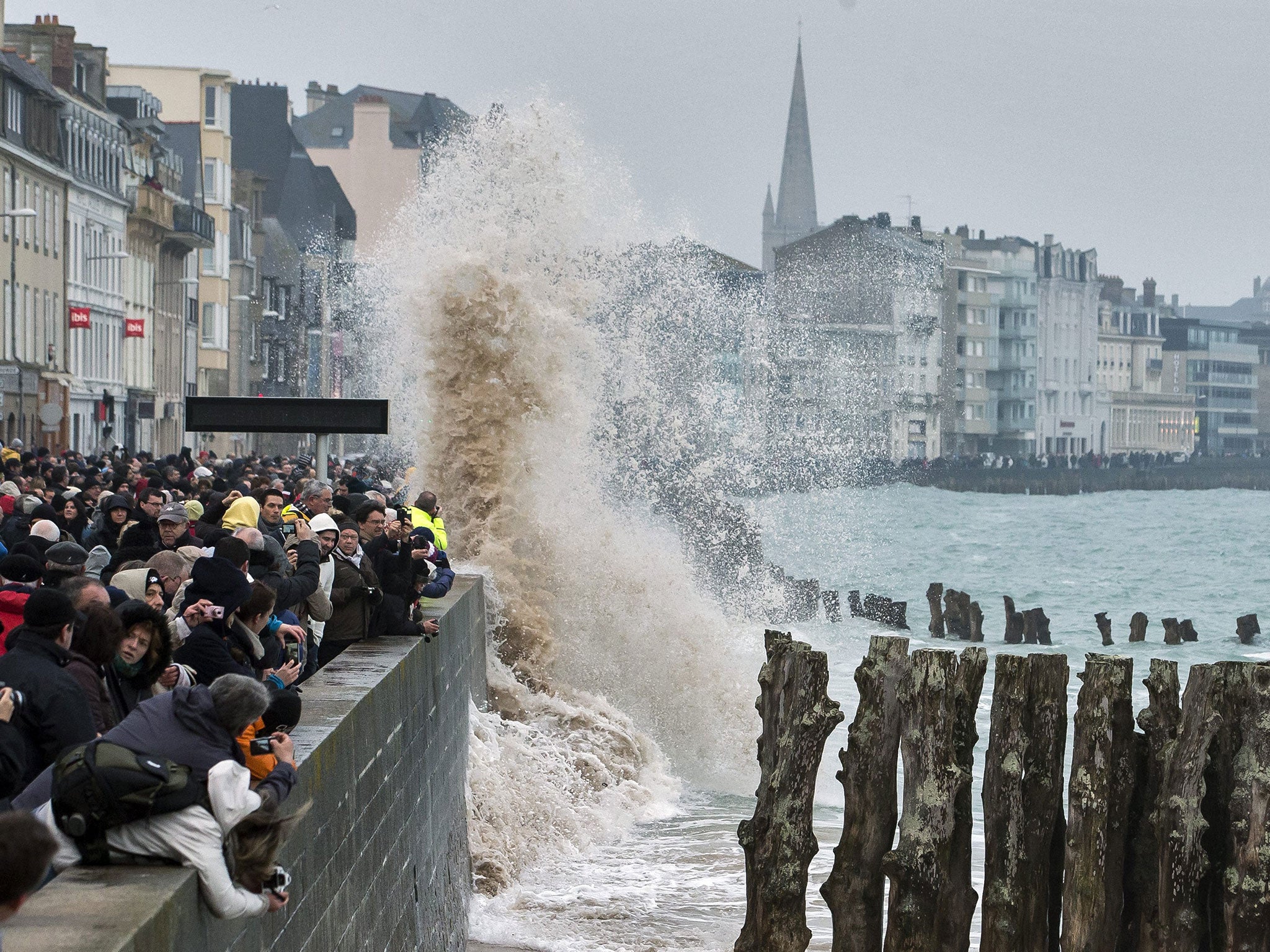 Large waves crash over the crowded waterfront during the incoming tide in Saint Malo, France, 21 March 2015