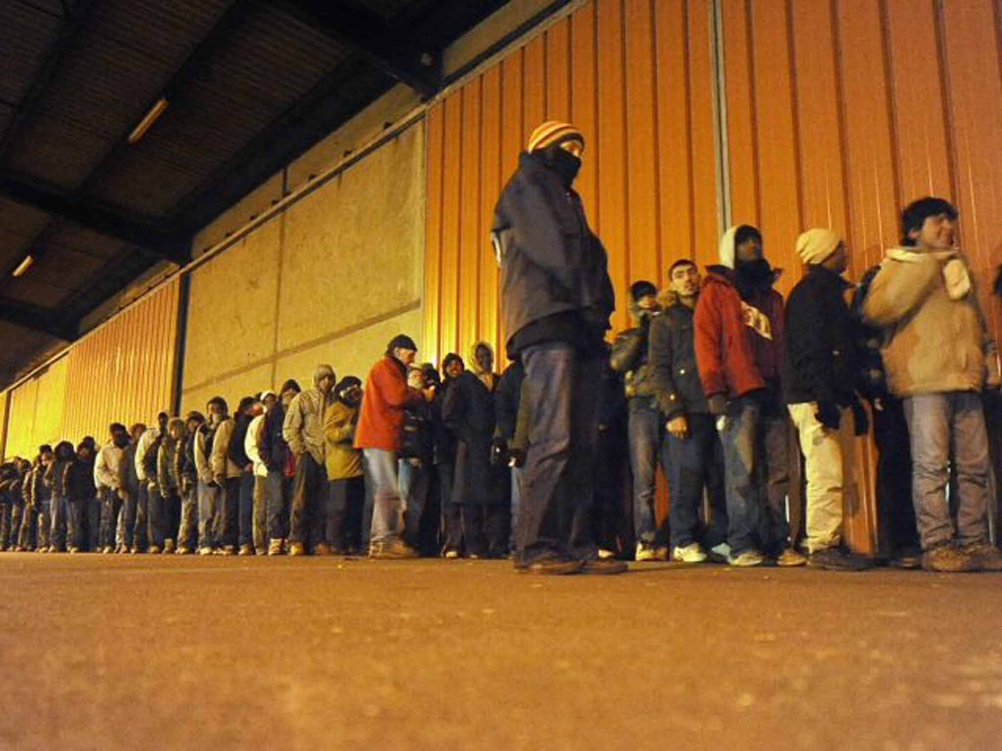 Hard line: migrants queue for food in Calais